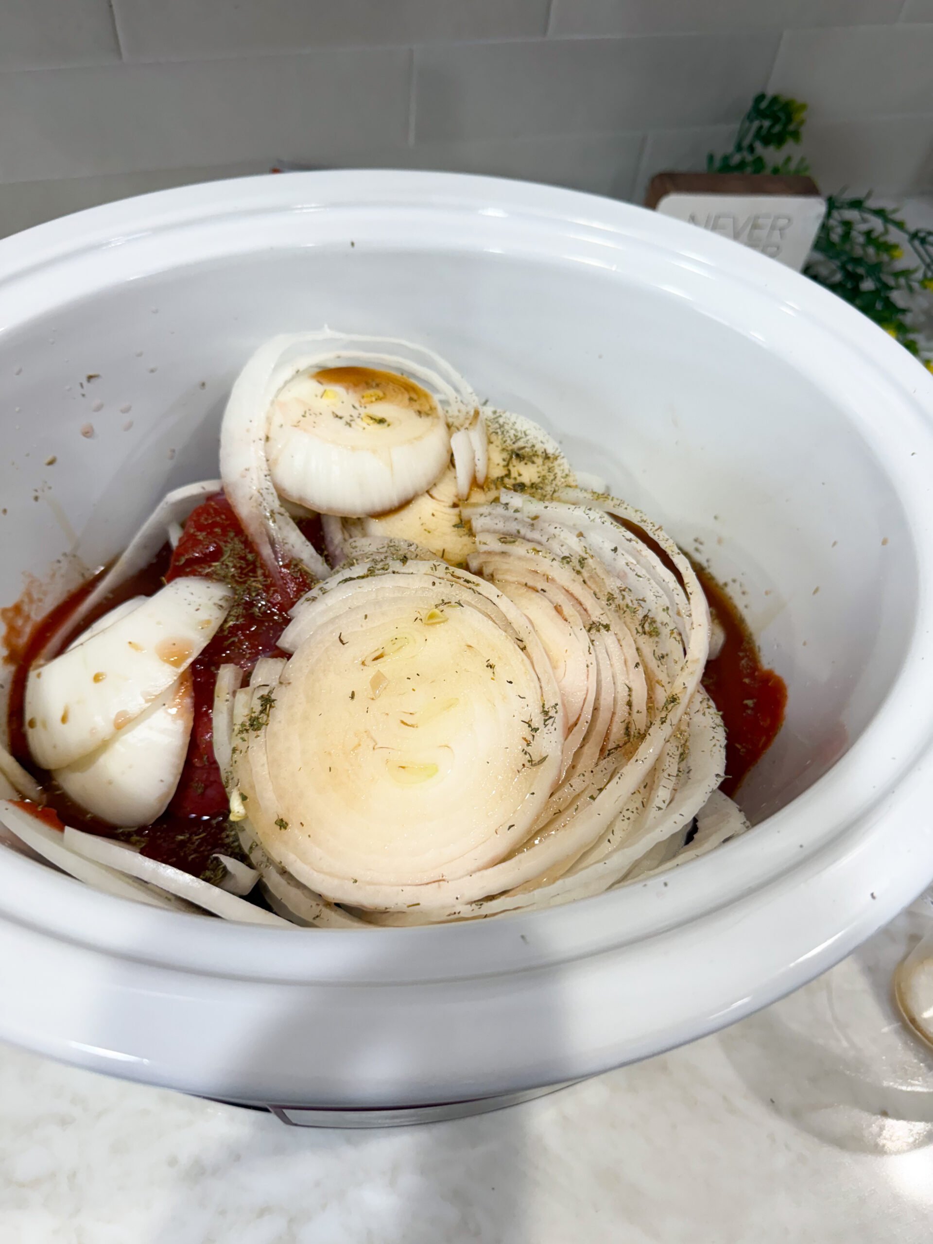 chuck roast, onions, and sauce in slow cooker