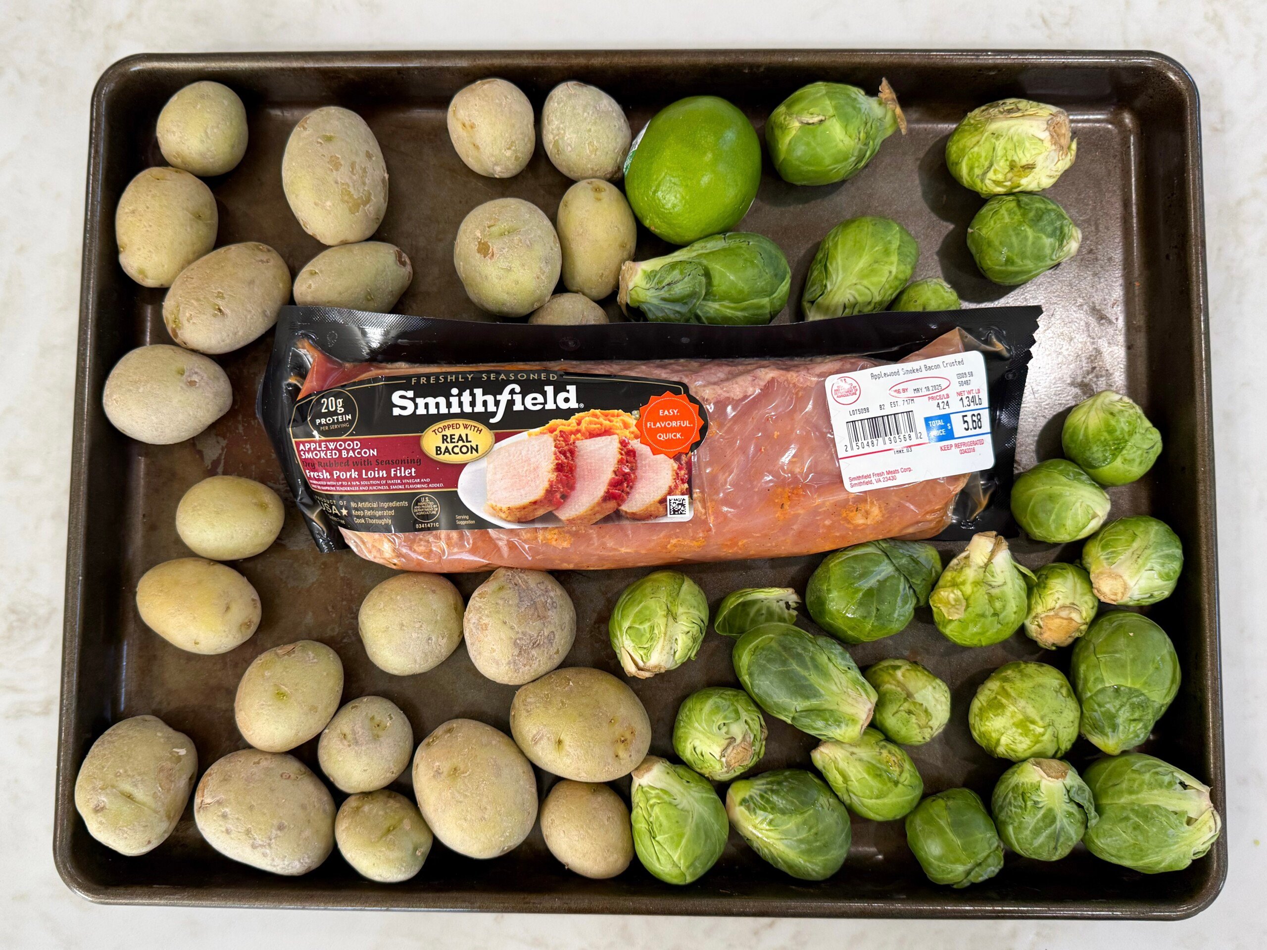 pork tenderloin and fresh vegetables arranged on a sheet pan