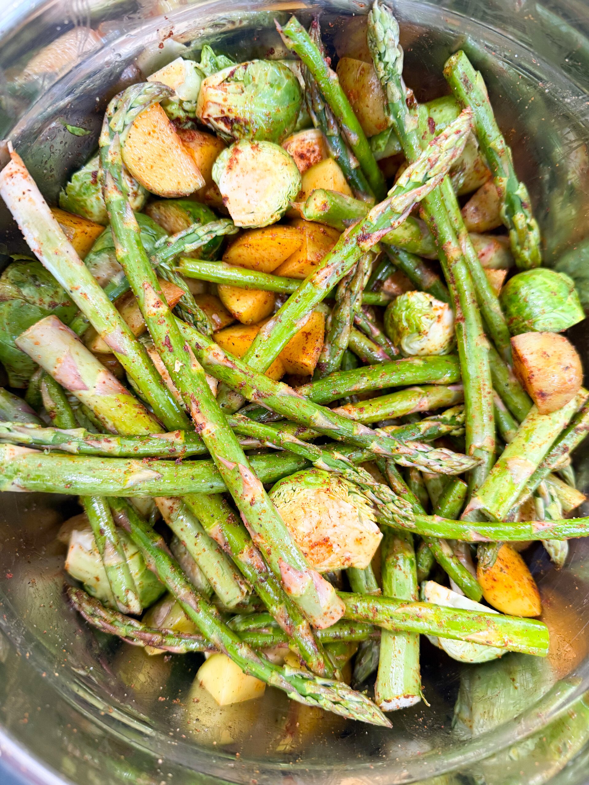 vegetables tossed with oil and seasonings in a bowl