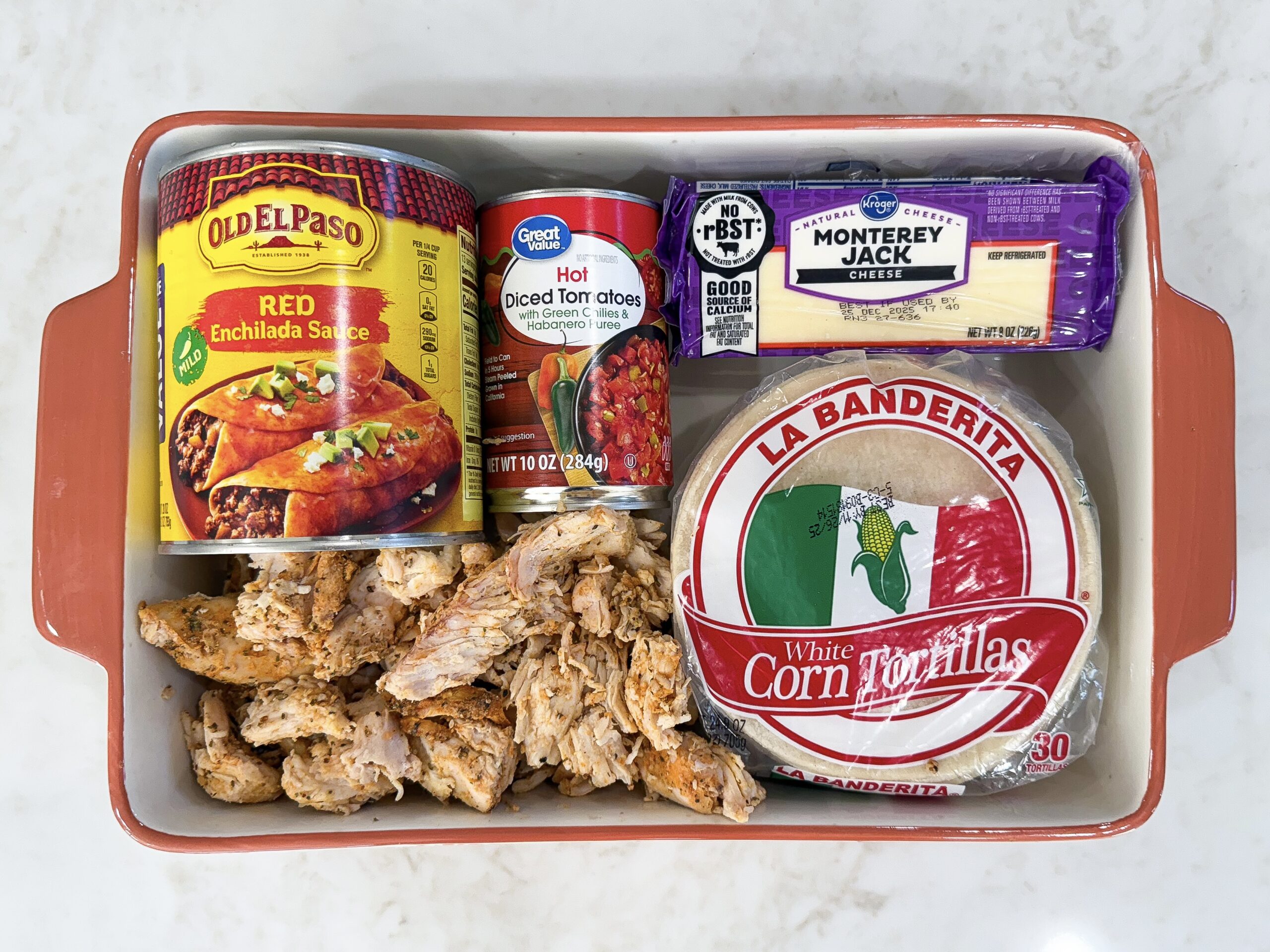 Ingredients for red chili chicken enchiladas in casserole dish