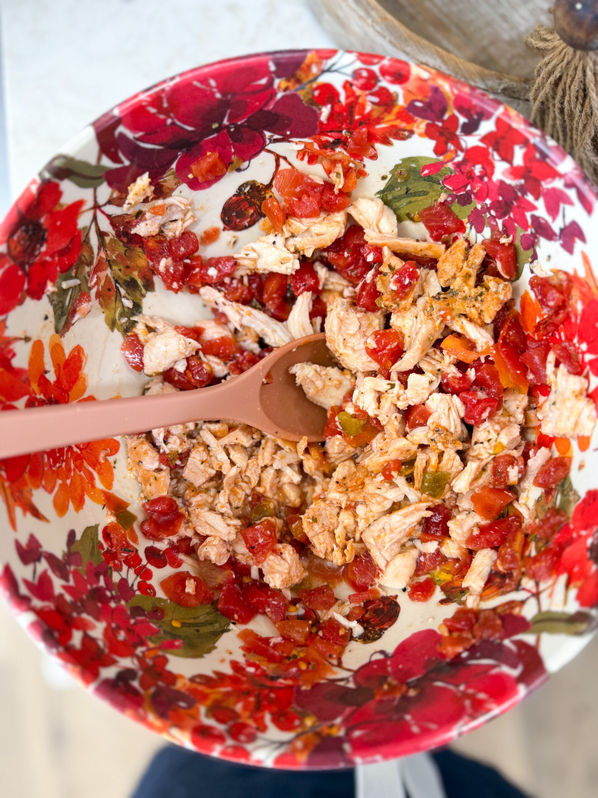 Mixing shredded chicken and Rotel in bowl