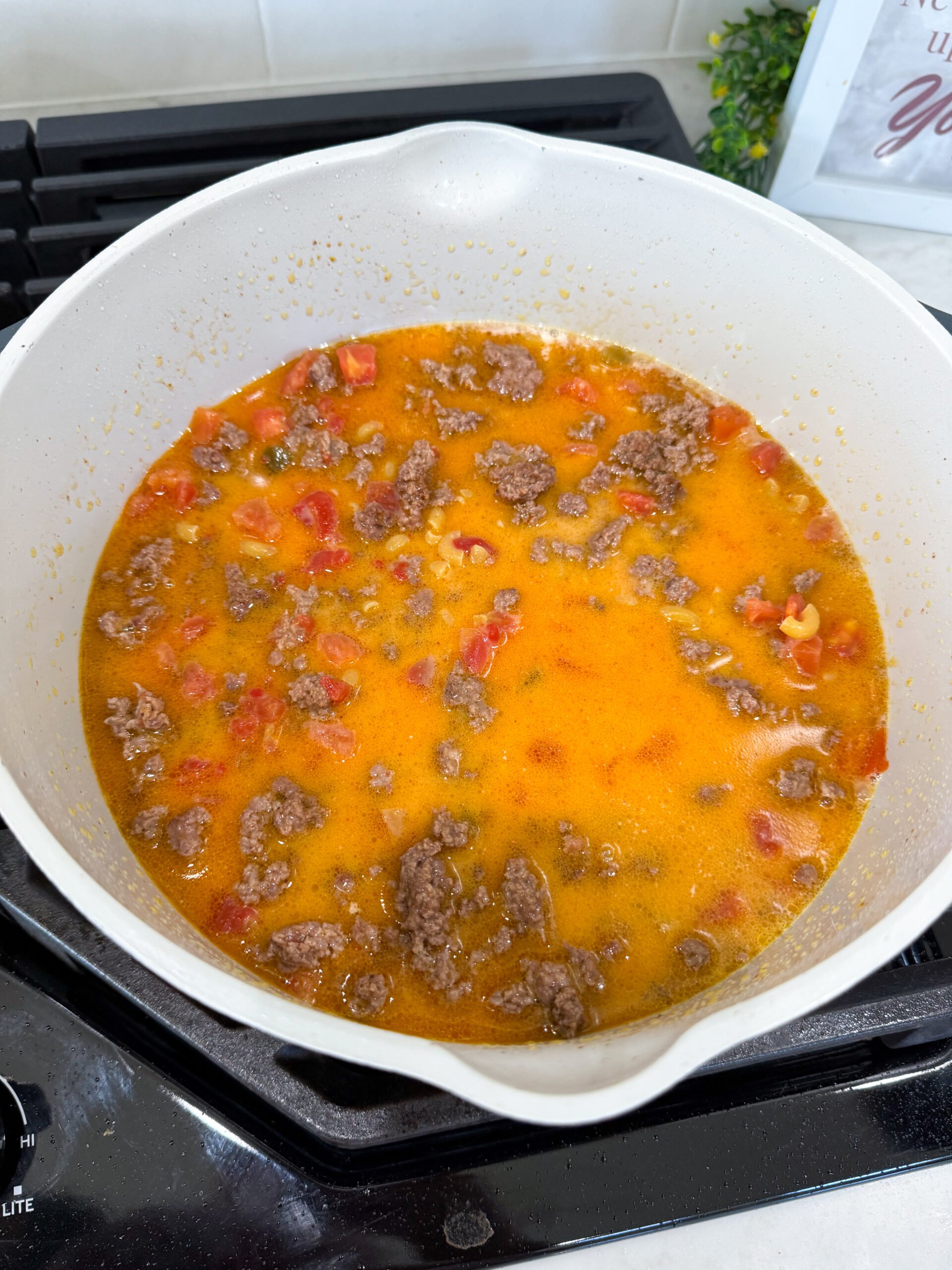 stirring in the cheese for the final step of cooking taco pasta.