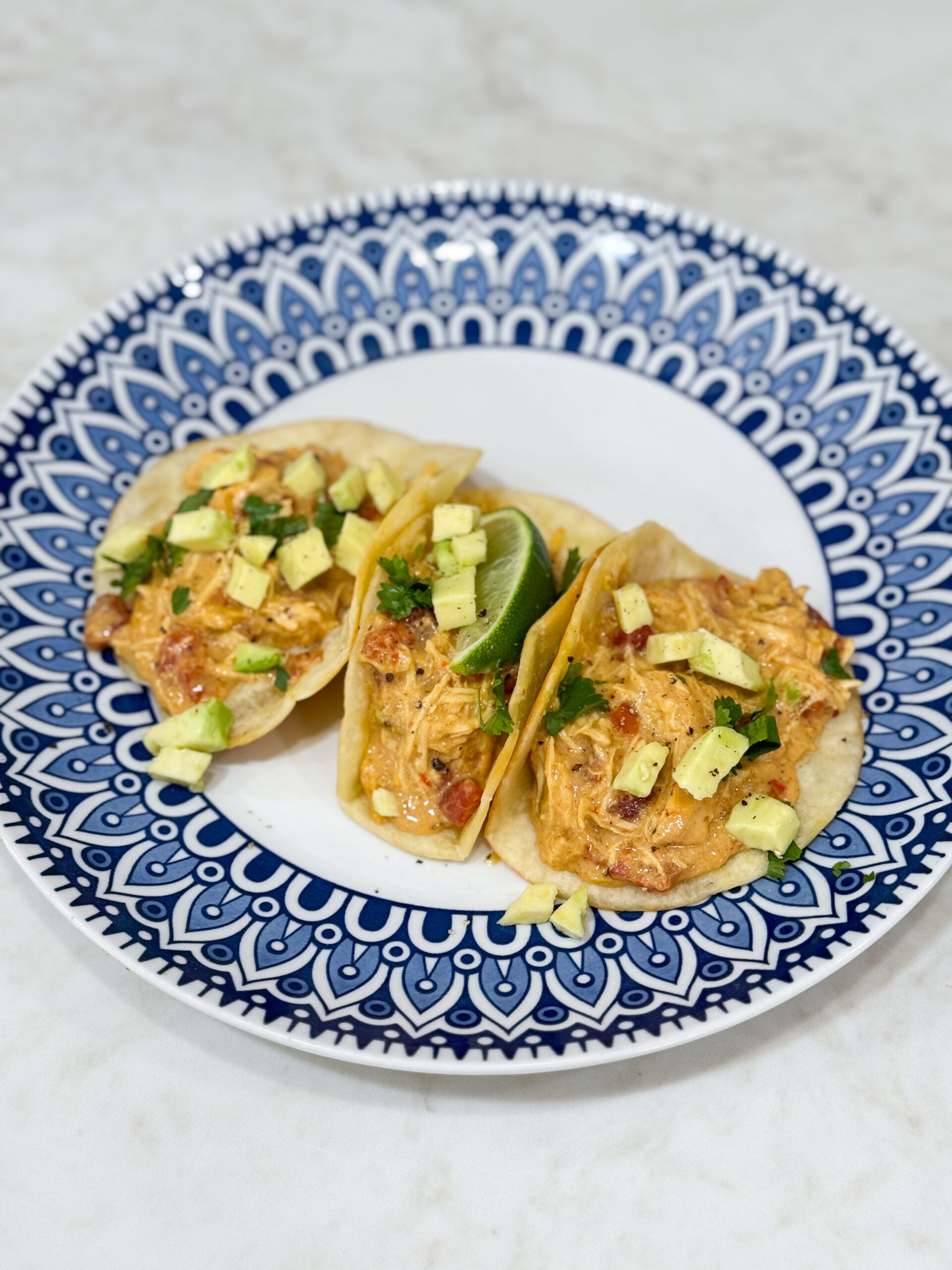 Tacos filled with creamy queso chicken and toppings