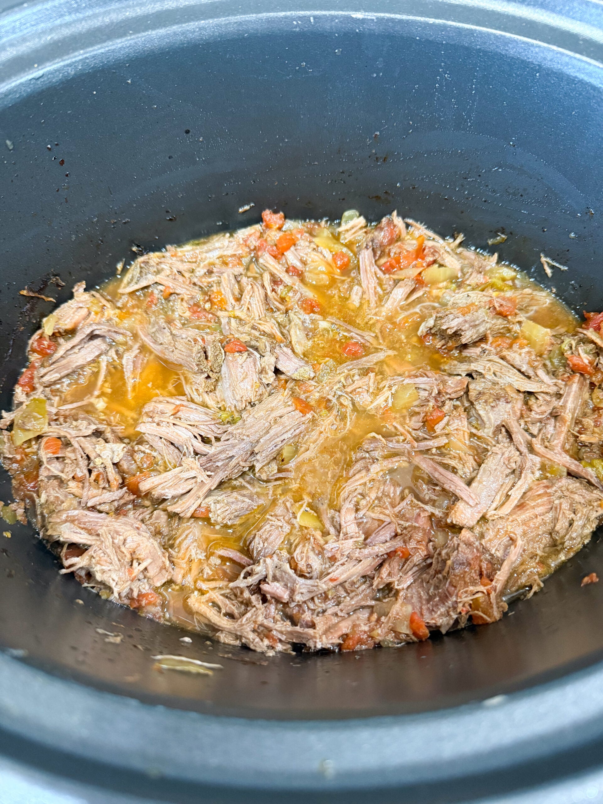 shredded carne asada stirred in slow cooker