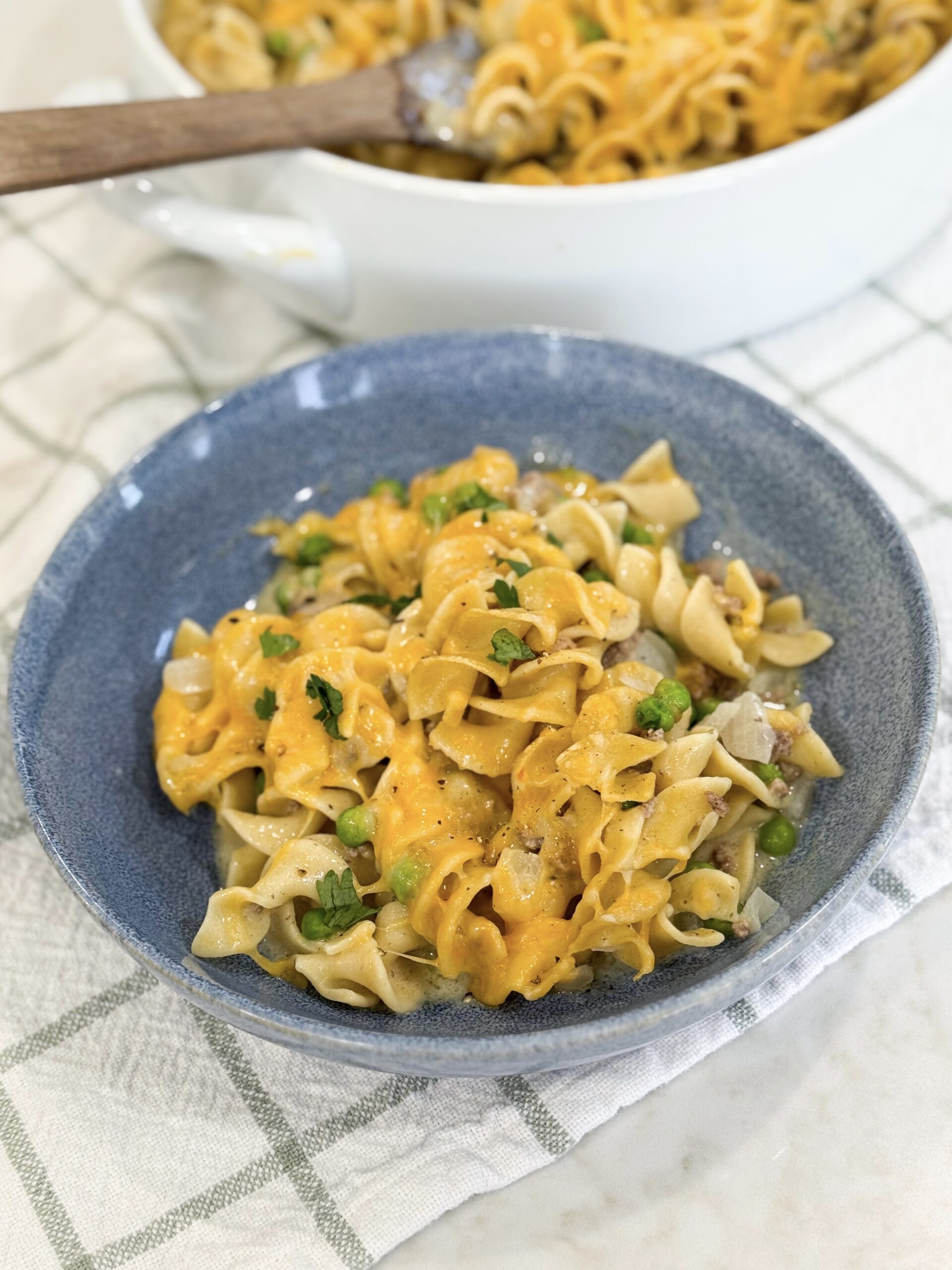 Ground beef stroganoff casserole in a baking dish topped with melted cheese