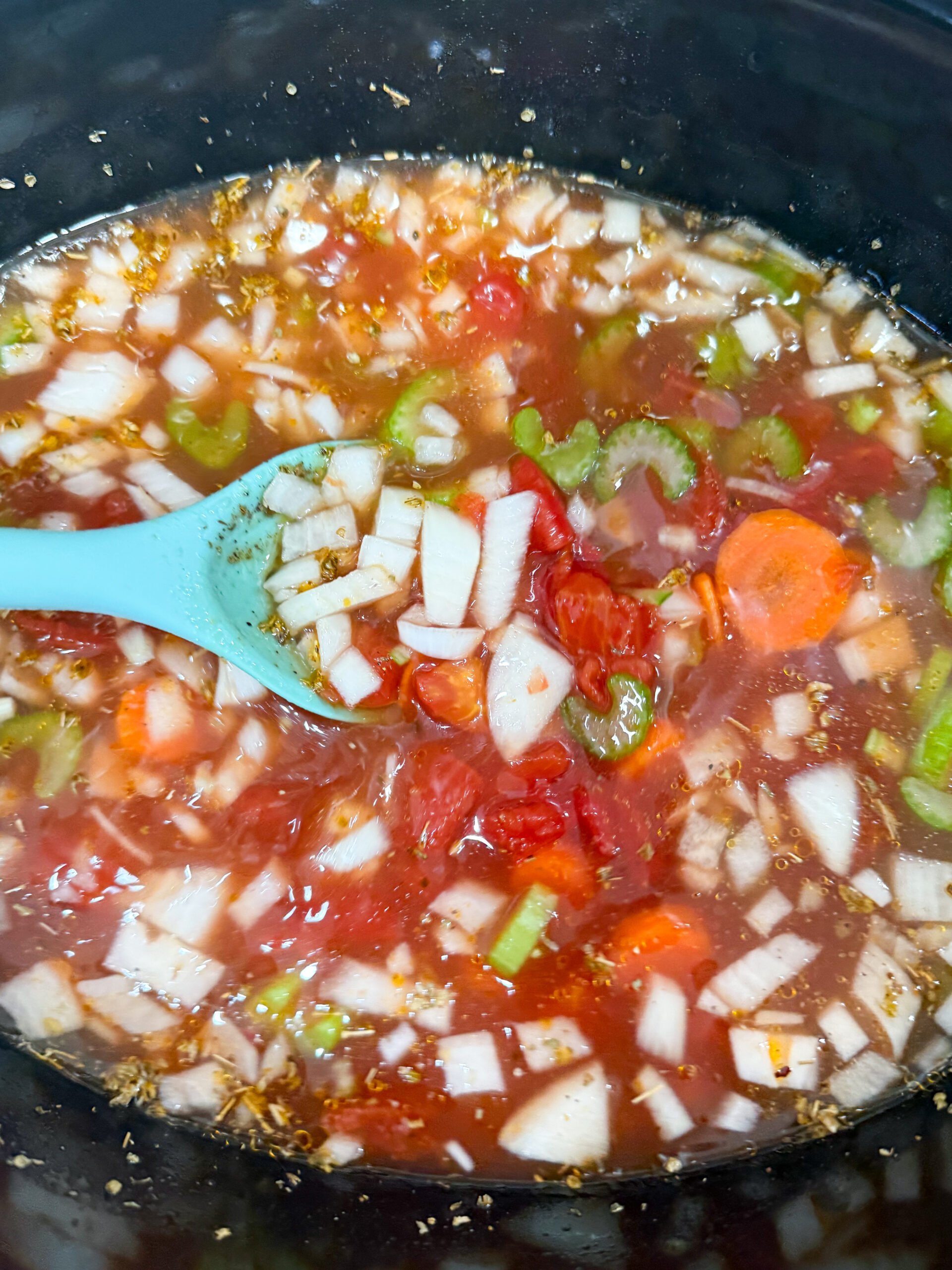 Adding vegetables and broth to slow cooker for minestrone