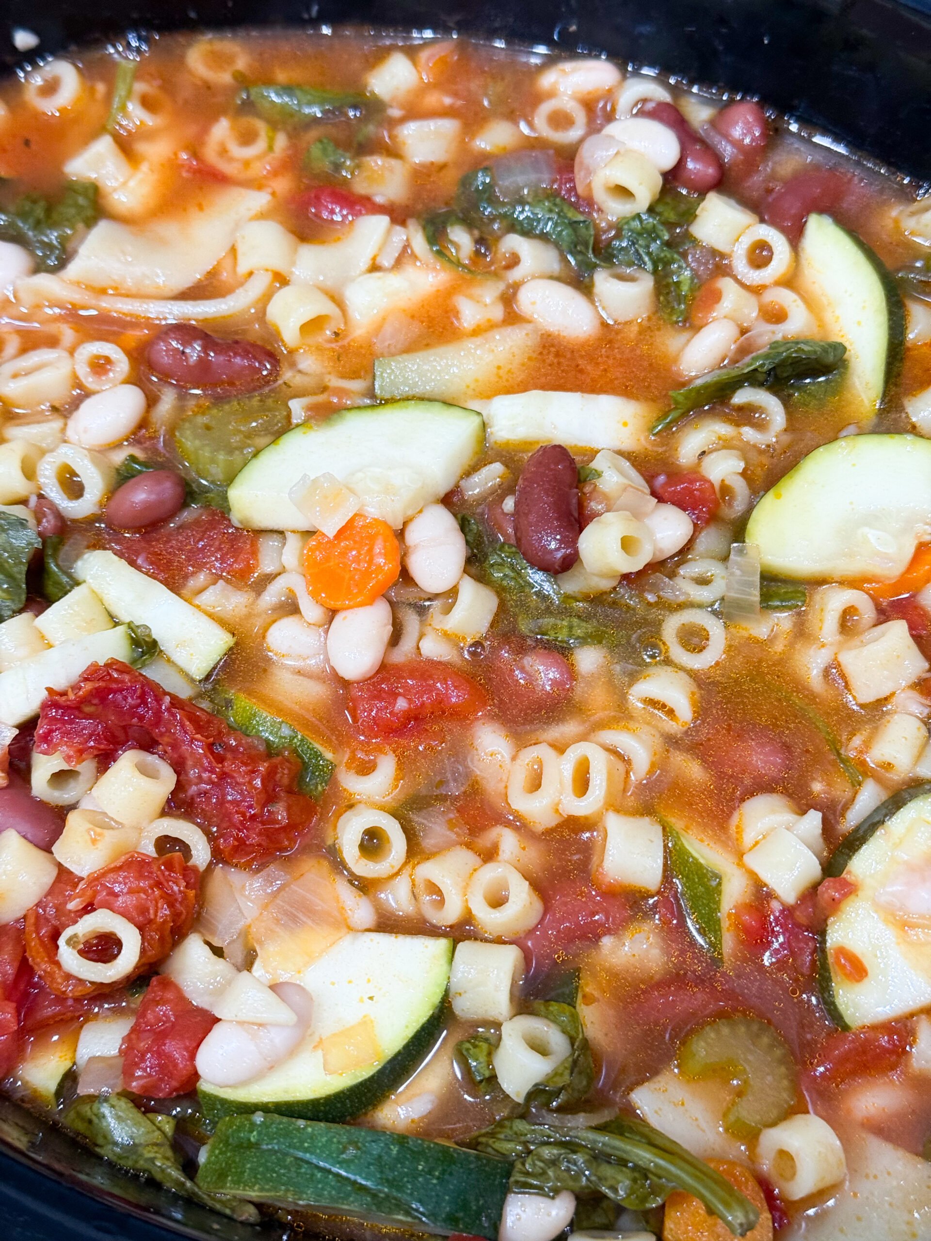 Minestrone soup in slow cooker with vegetables and pasta