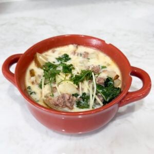 Bowl of zuppa toscana soup topped with Parmesan
