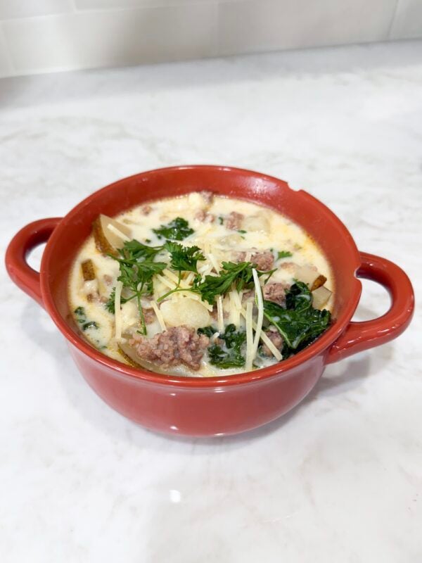 Bowl of zuppa toscana soup topped with Parmesan
