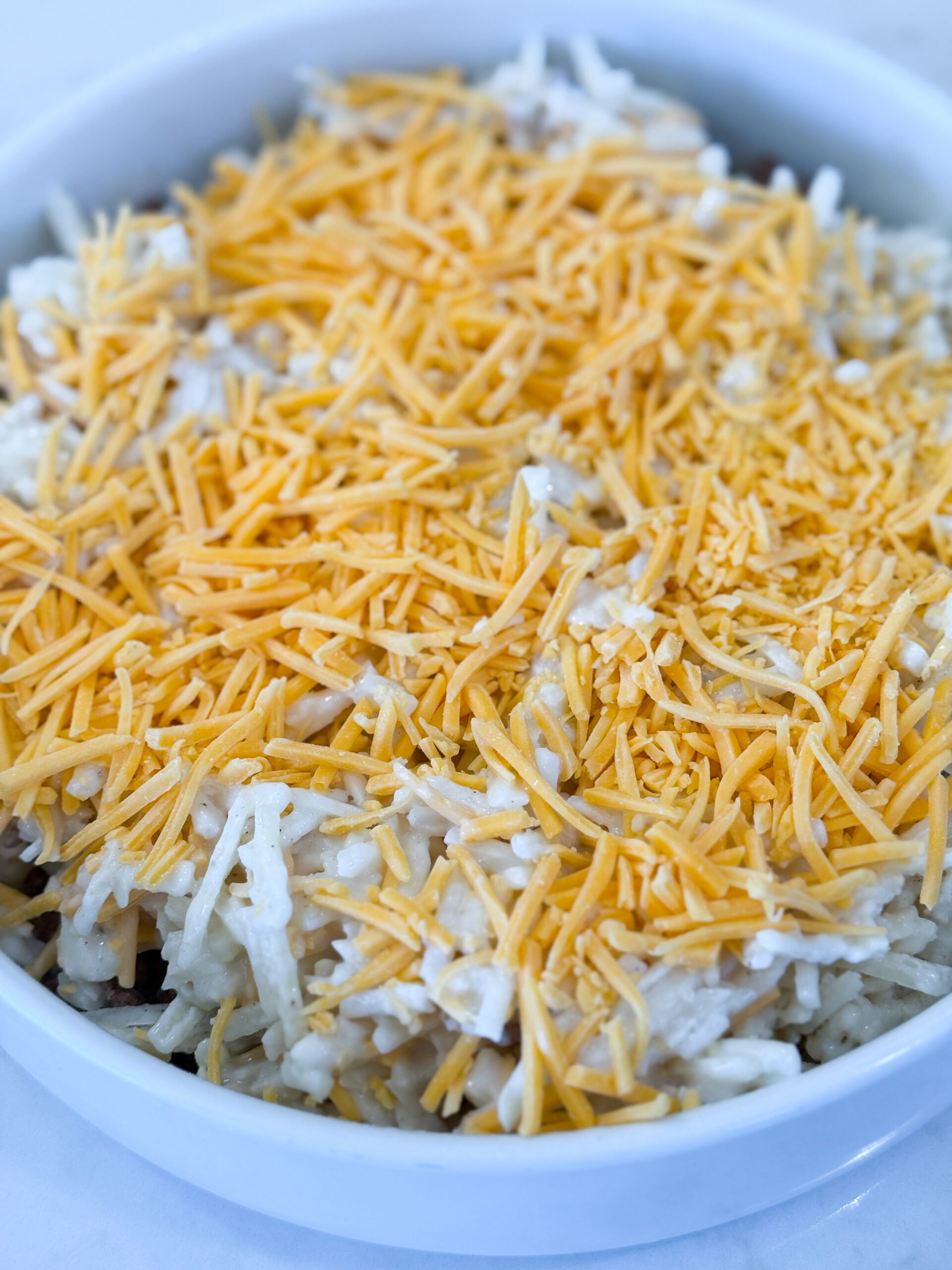 Layering beef and hashbrown mixture in baking dish