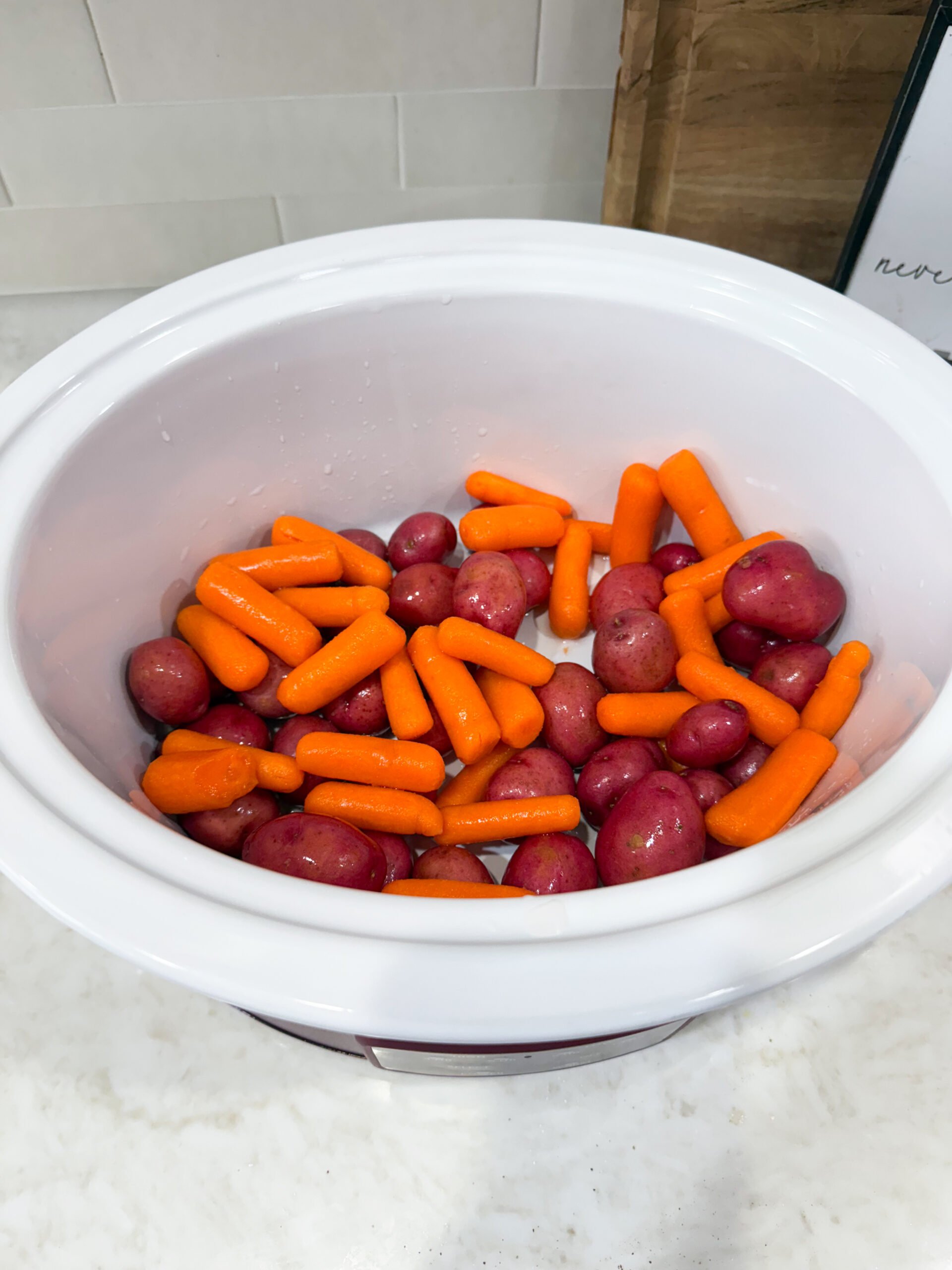 potatoes and carrots placed in the slow cooker
