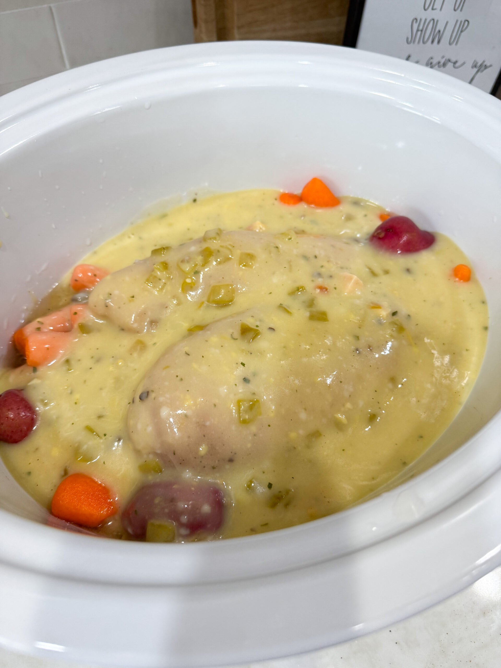 chicken placed over vegetables with sauce poured on top