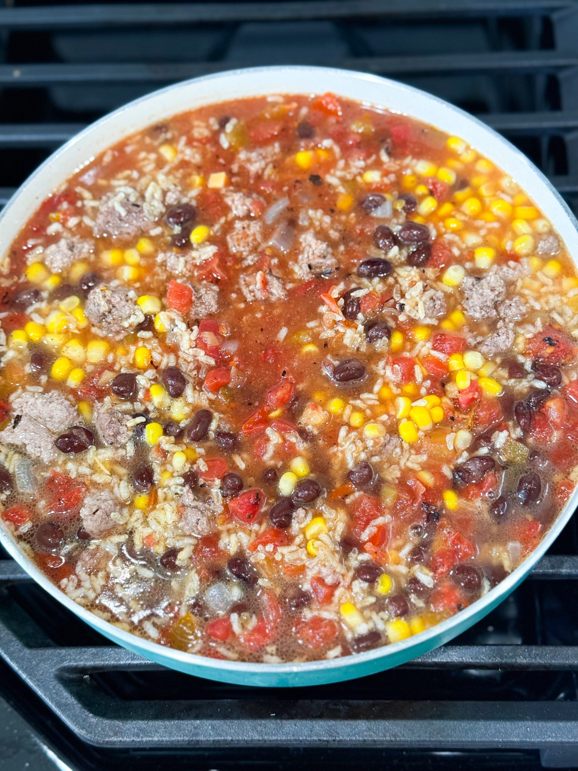 Rice, beans, salsa, and corn simmering together in pot
