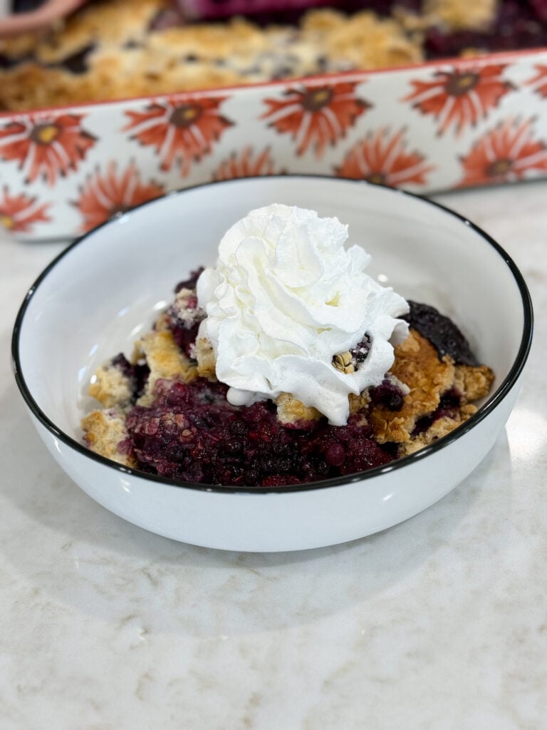 Baked berry cobbler topped with scoop of vanilla ice cream