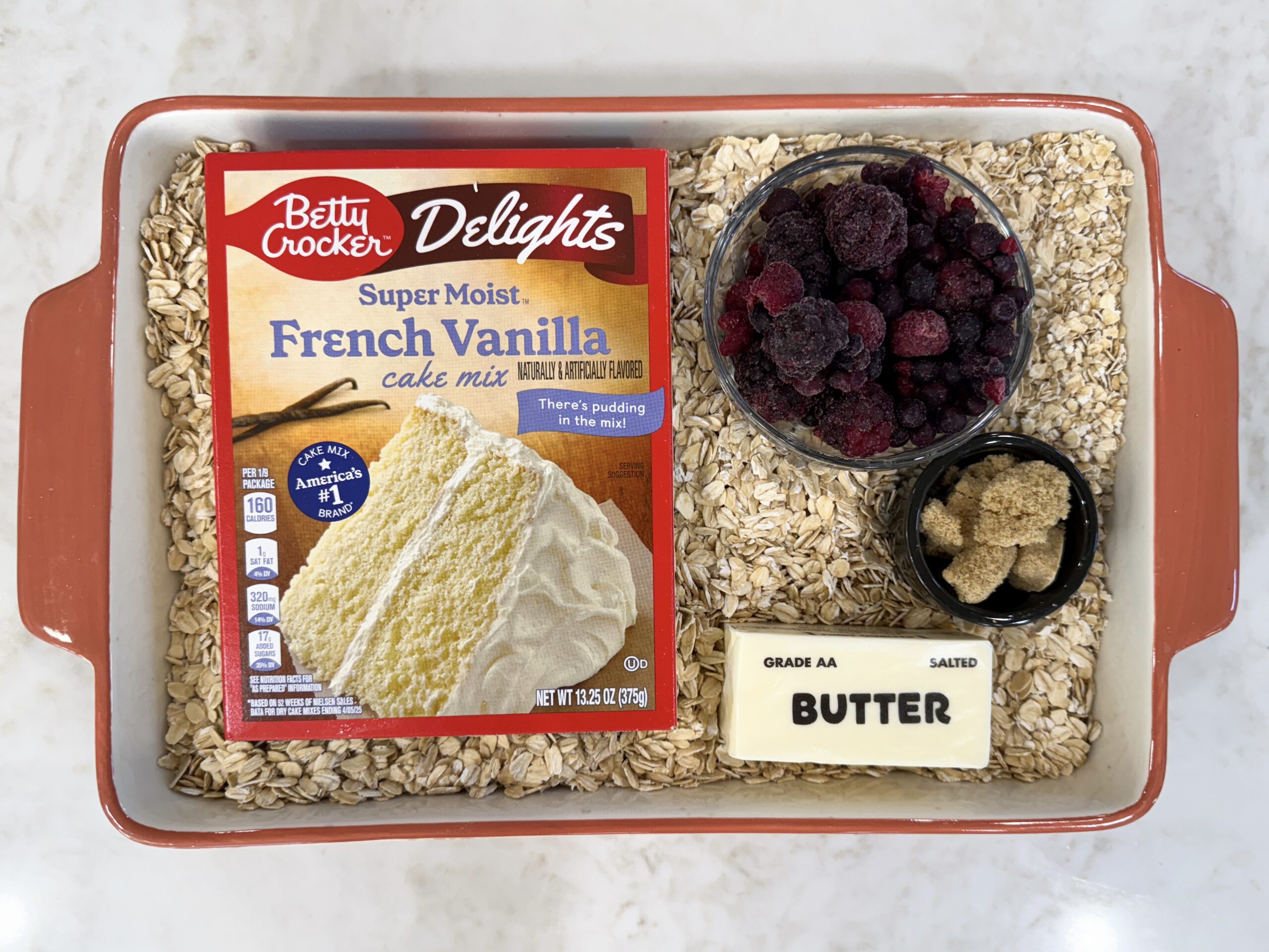 Ingredients for berry cobbler in casserole dish