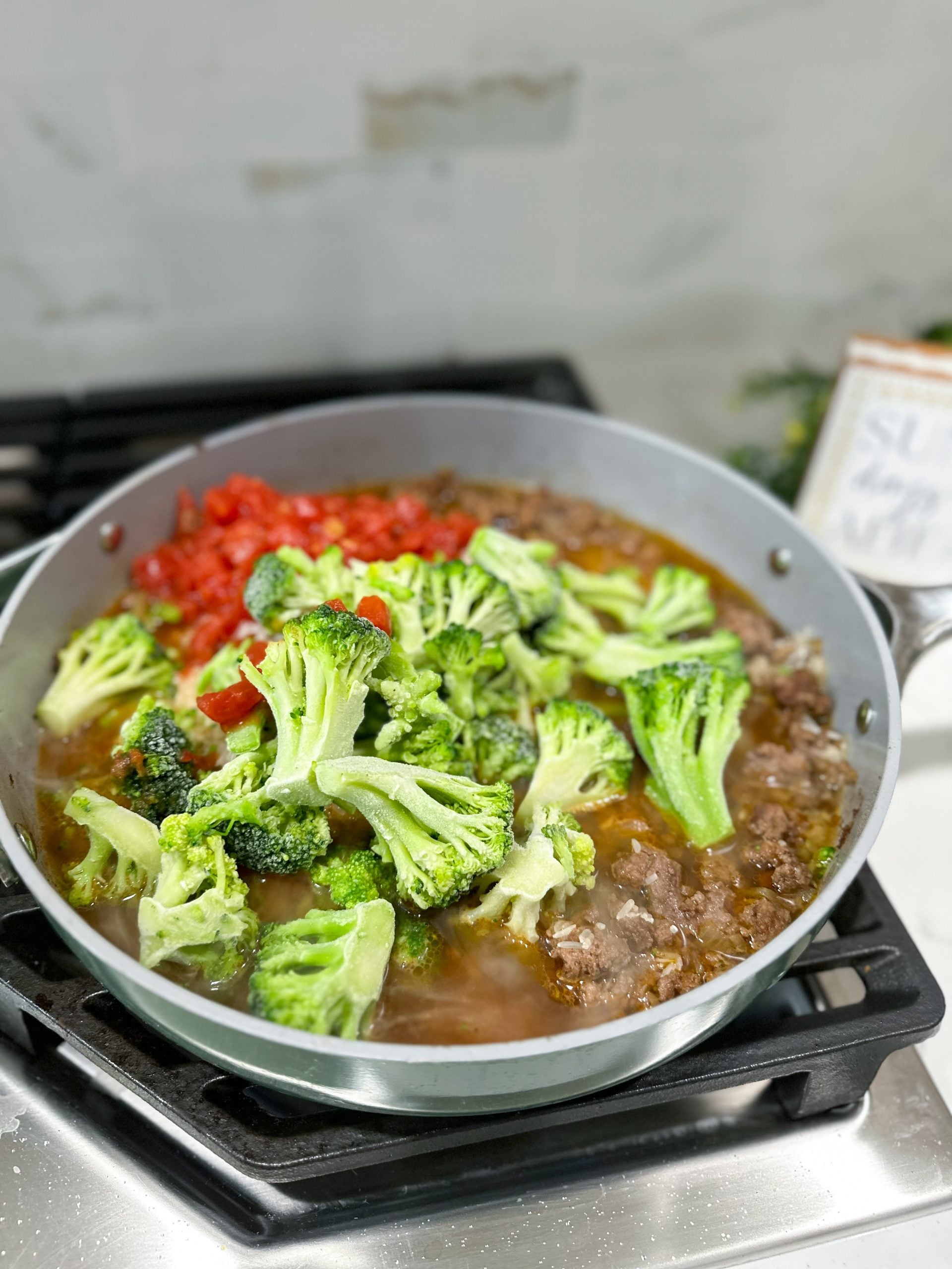 Rotel, broccoli, and broth added to the skillet.