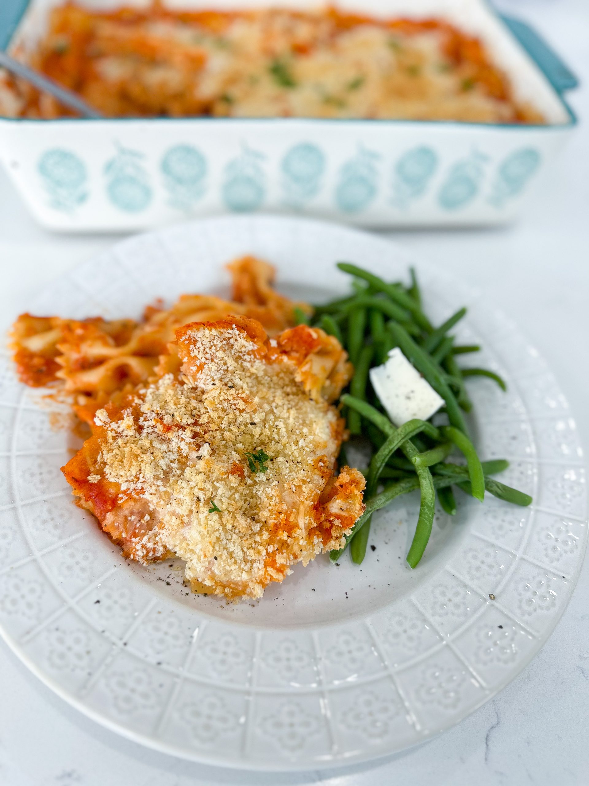 Baked chicken parmesan casserole topped with melted cheese and breadcrumbs