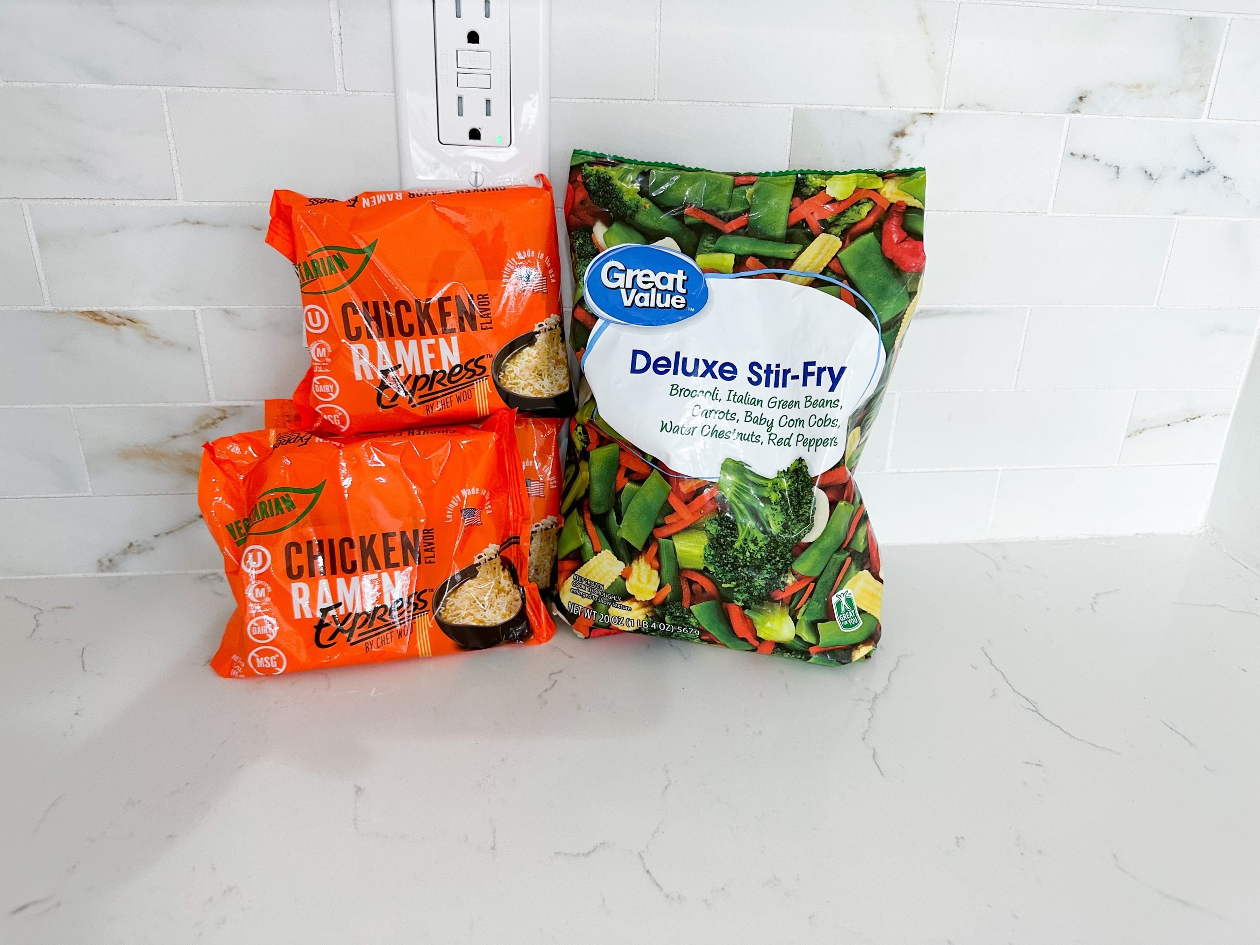 Ingredients for ramen noodle stir fry including noodles, vegetables, and soy sauce