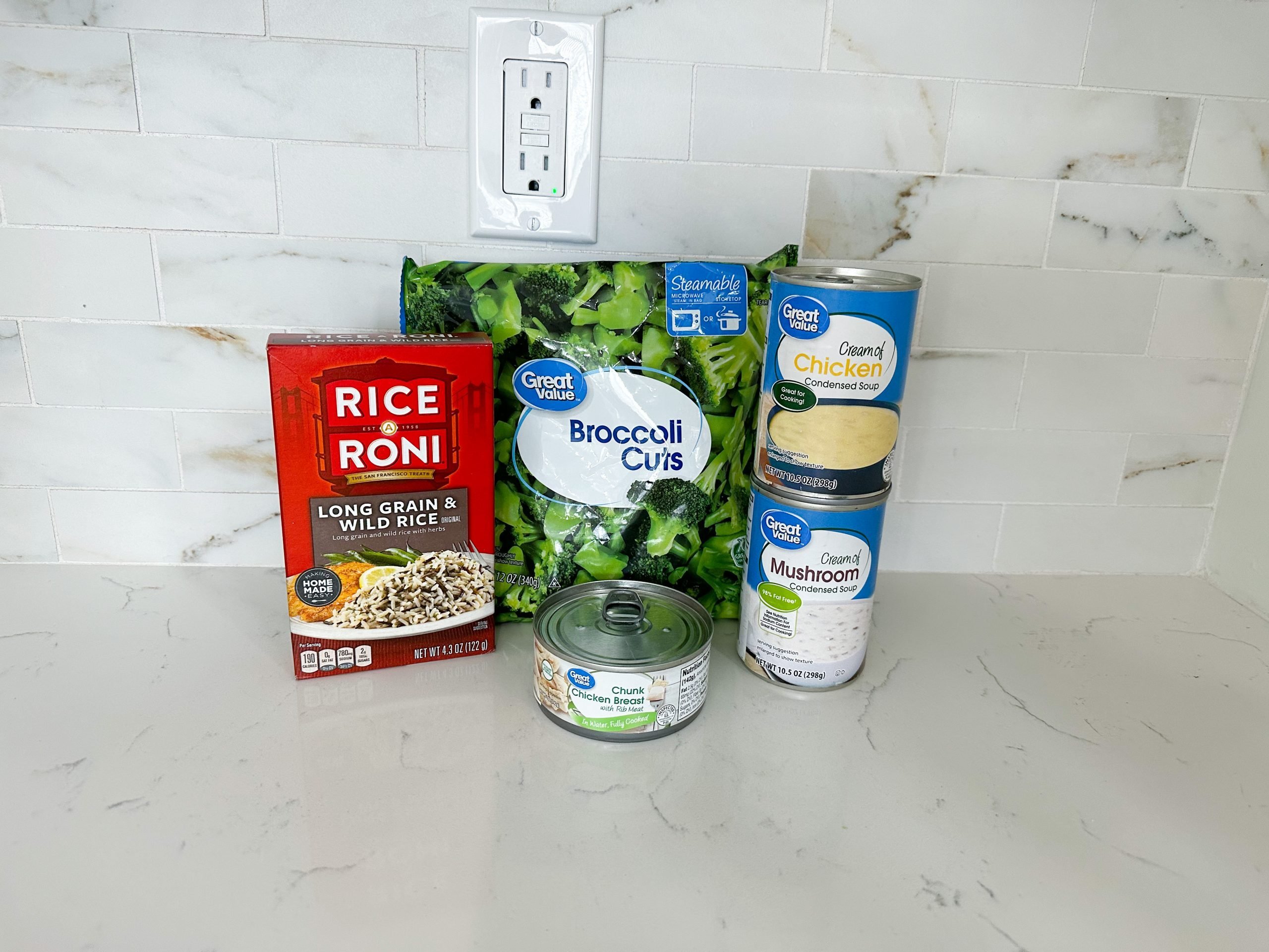 Ingredients for chicken and rice casserole including soups, broccoli, and rice mix