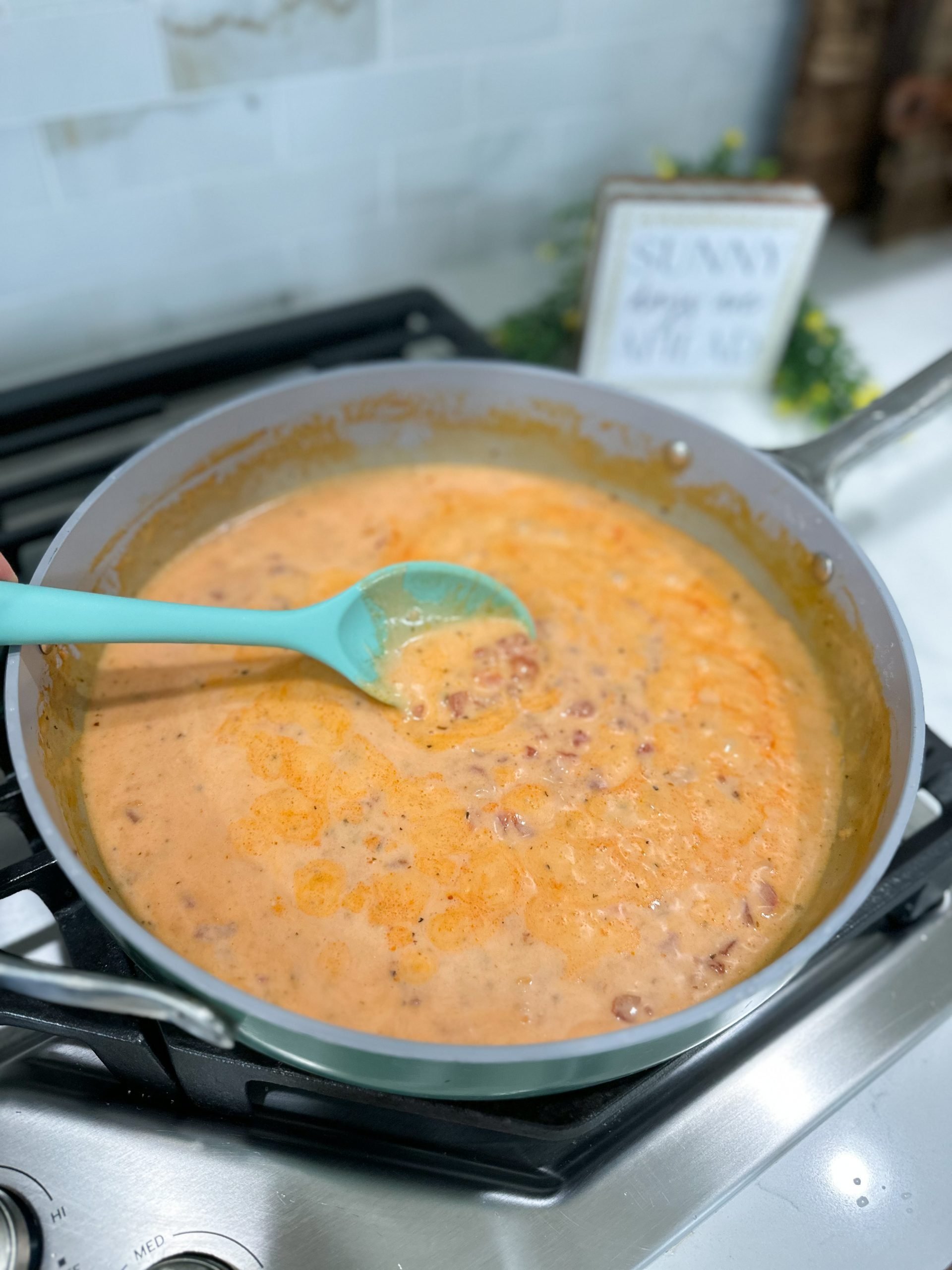 Alfredo and tomato sauce simmering in a skillet