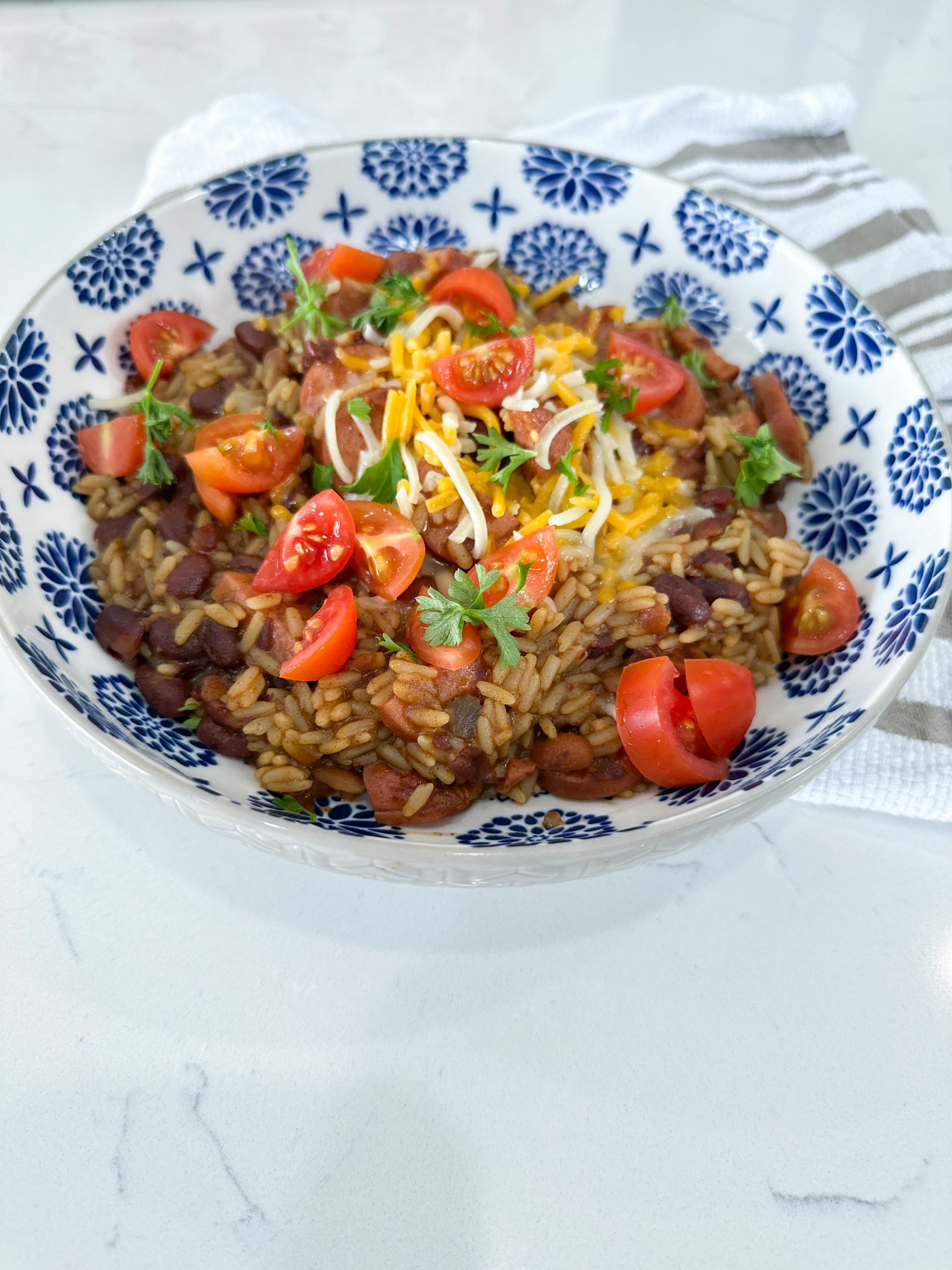 Bowl of red beans and rice with slices of browned sausage