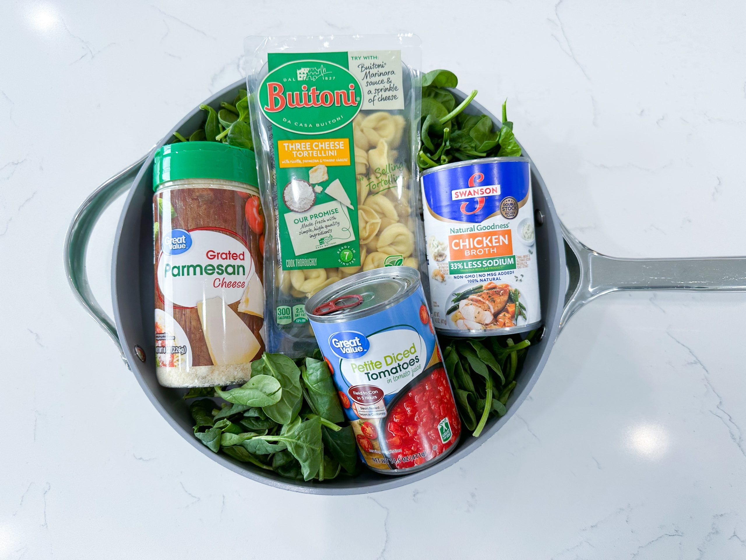 Ingredients for creamy skillet tortellini with spinach in a skillet.