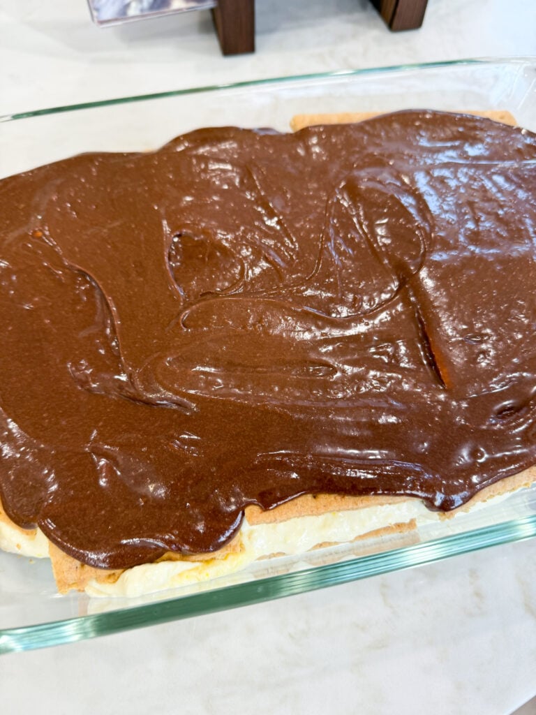 Eclair No-Bake Cake with graham crackers, creamy vanilla pudding, and chocolate frosting — a quick, delicious no-bake dessert!