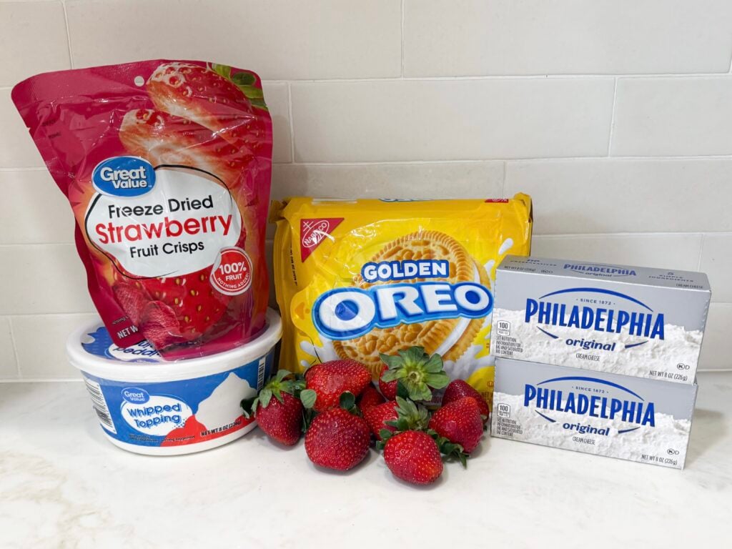 Ingredients for Strawberry Crunch Cheesecake laid out on countertop