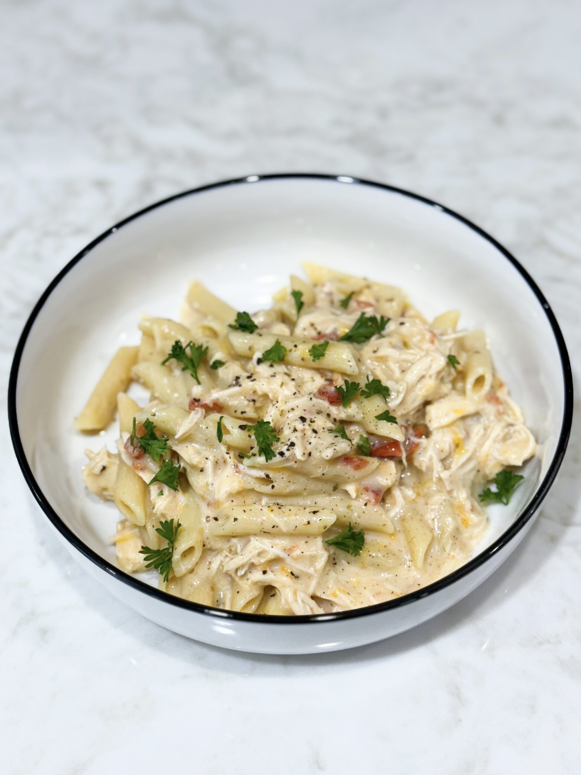 Slow cooker creamy chicken pasta topped with parsley