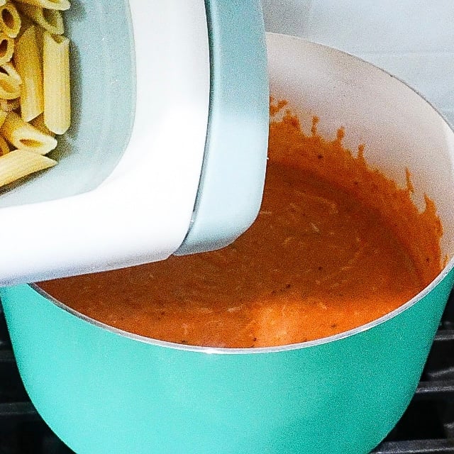 Mozzarella and Parmesan being stirred into sauce