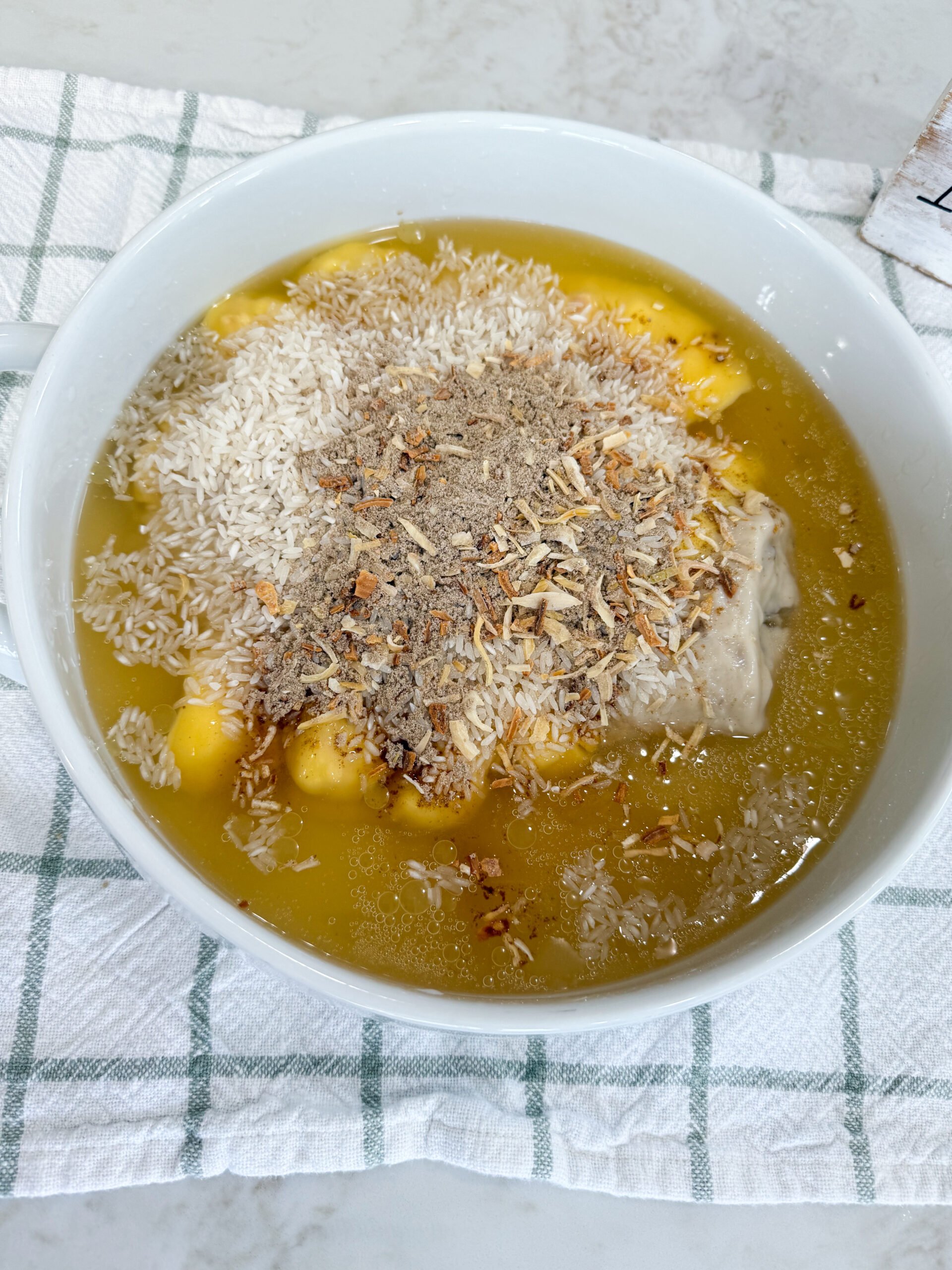 Raw pork chops placed on top of rice and soup mixture in baking dish with remaining onion soup mix sprinkled evenly over pork chops.