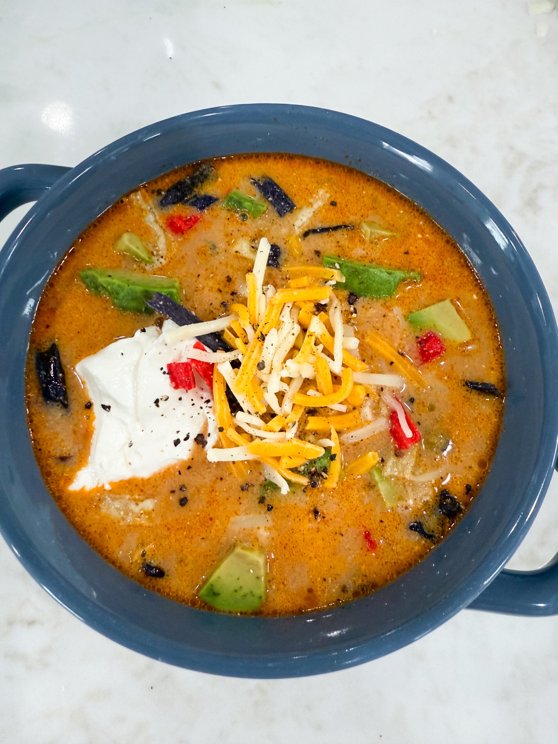 creamy tortilla soup with chicken, black beans, corn, and melted cheese