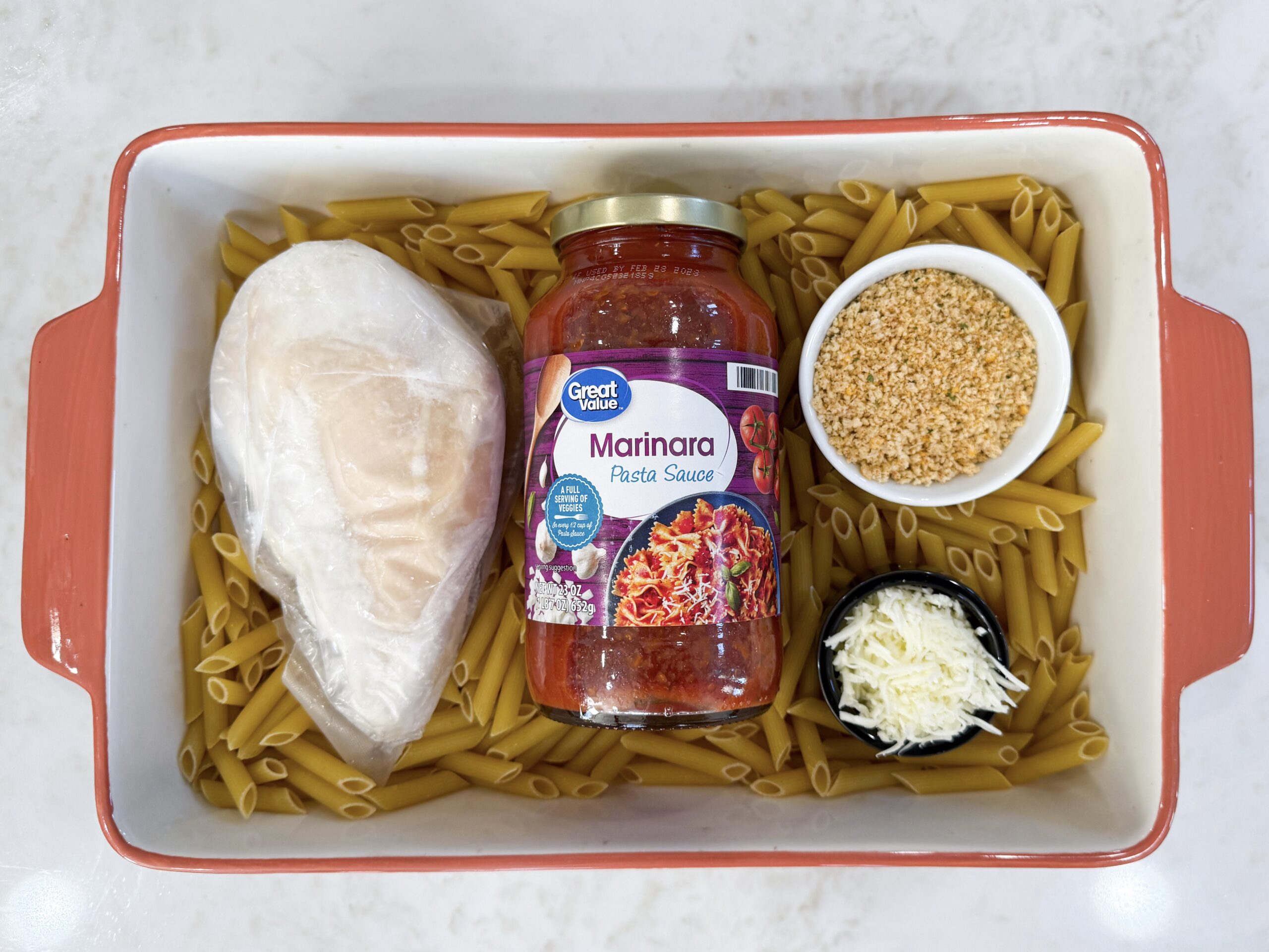 Ingredients for chicken parmesan casserole in casserole dish