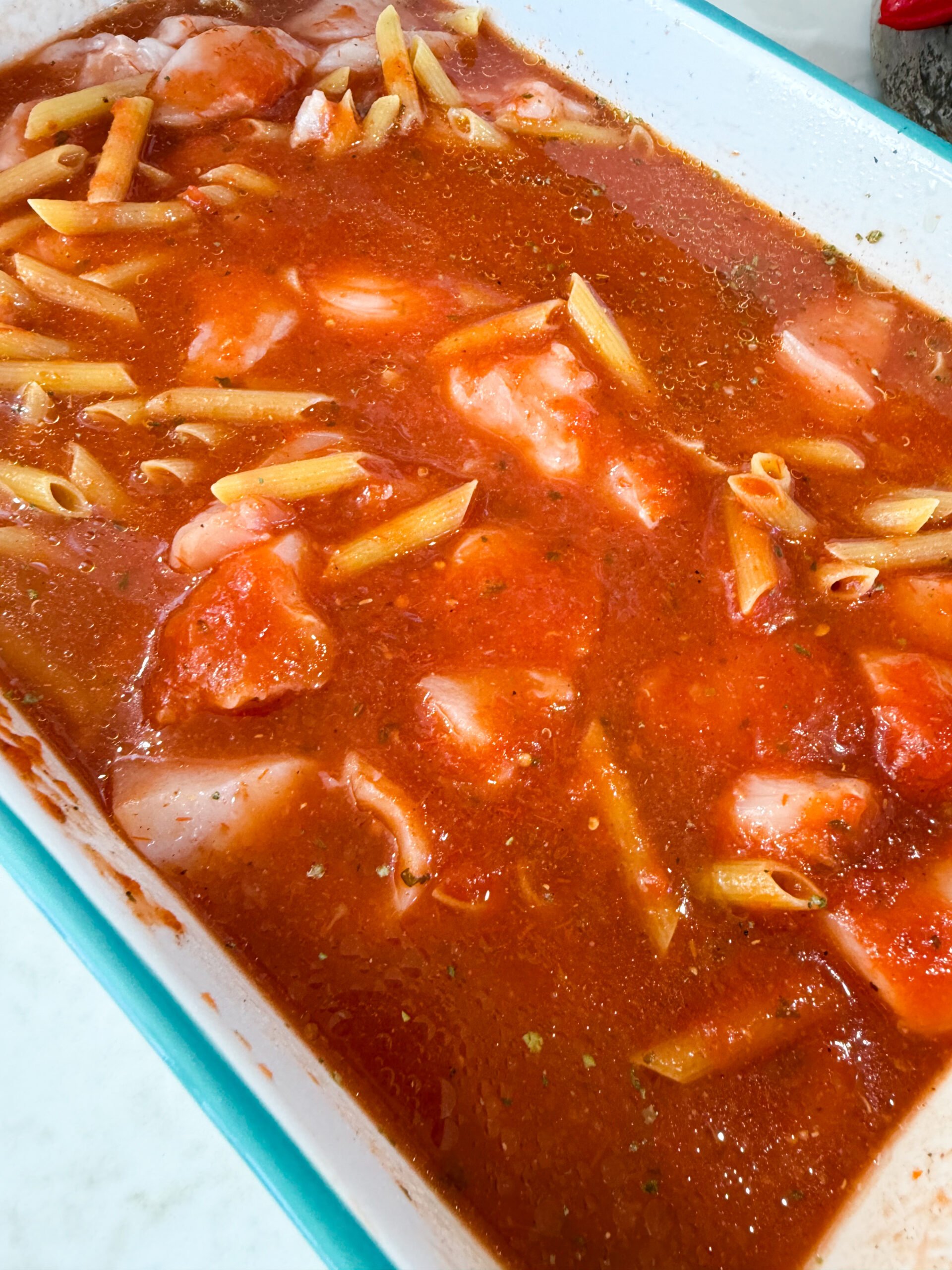 Mixing pasta, sauce, and chicken in baking dish