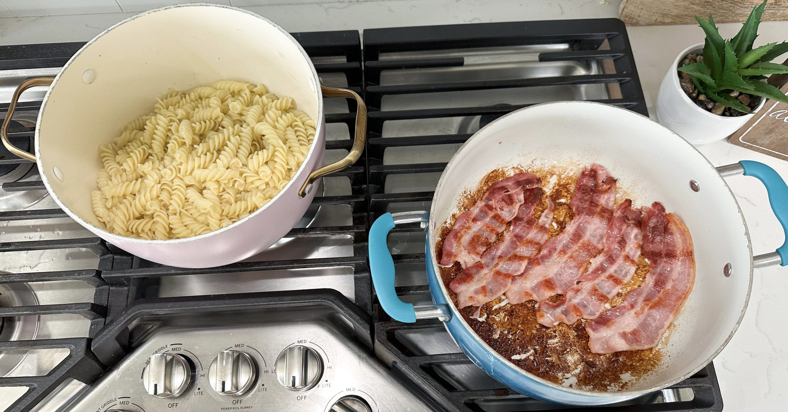 bacon cooking in skillet and finished pasta noodles drained in a pot