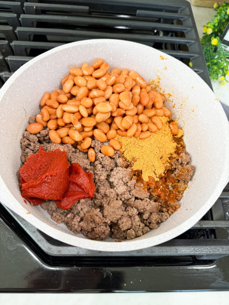 add beans and tomato paste to meat