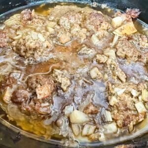 ground meat cooked in a black slow cooker