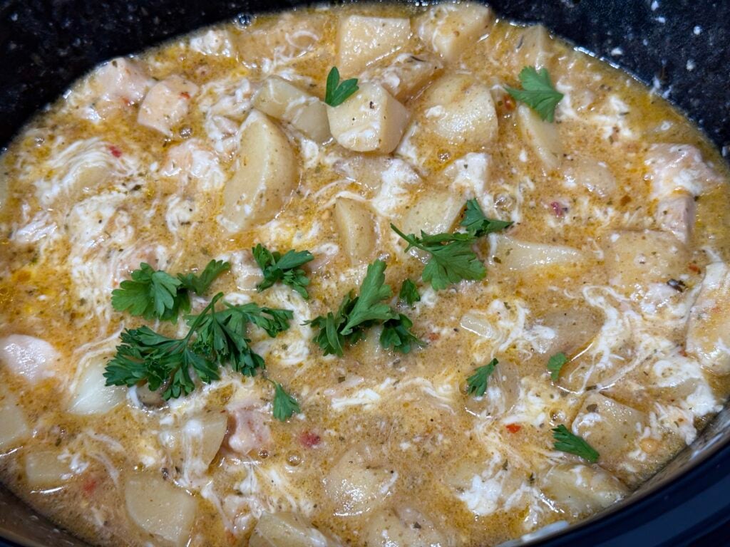creamy parmesan sauce with cooked chicken and fresh parsley