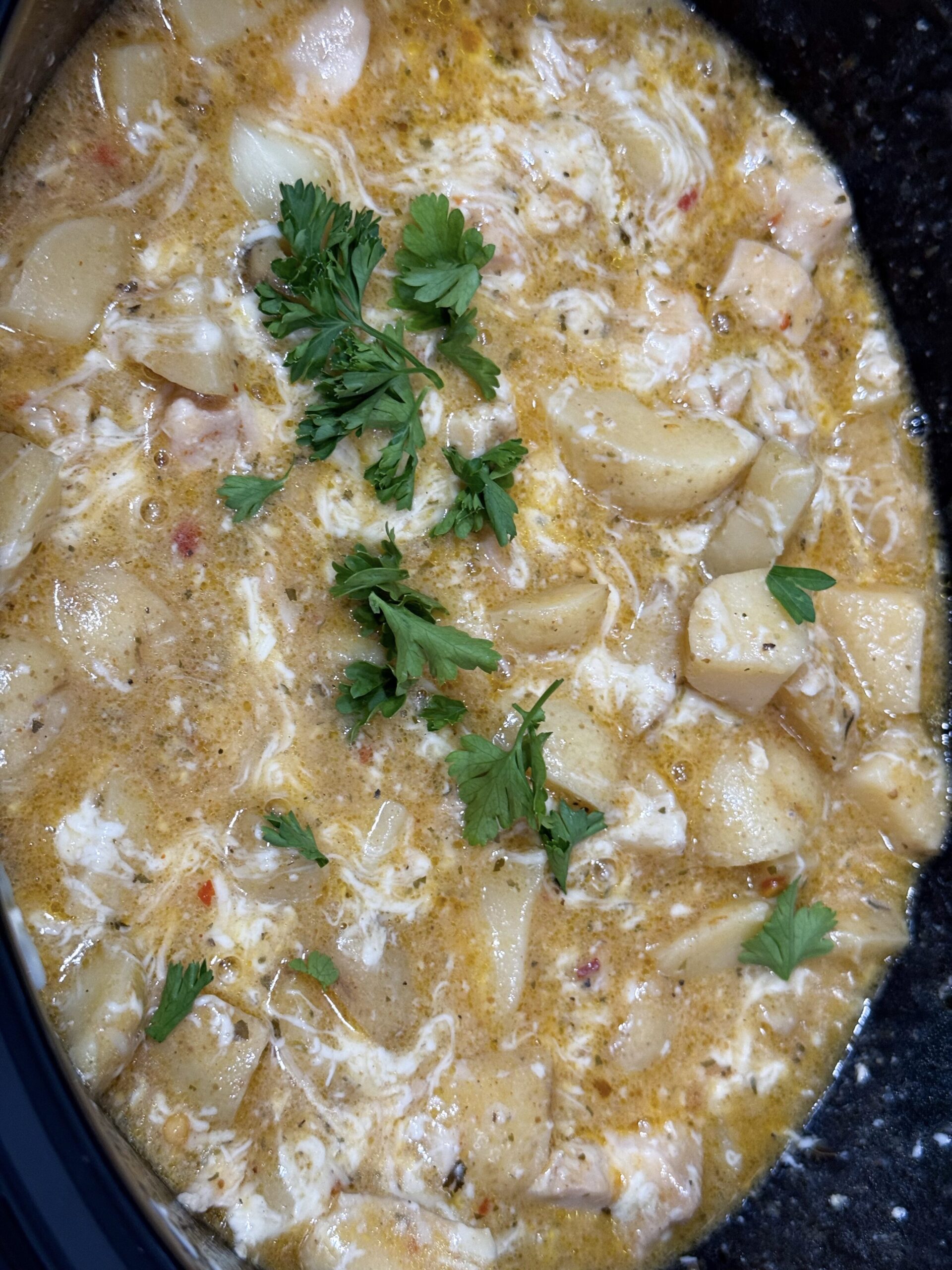 creamy parmesan sauce with cooked chicken and fresh parsley