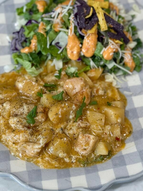 chicken and potatoes on a blue and white plate with salad