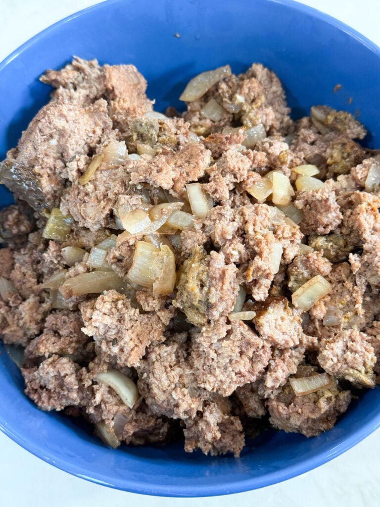cooked ground beef and onions in a blue bowl