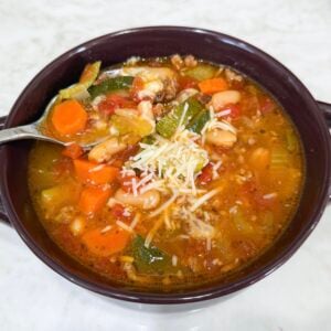 Bowl of Italian Vegetable and Sausage Soup topped with Parmesan