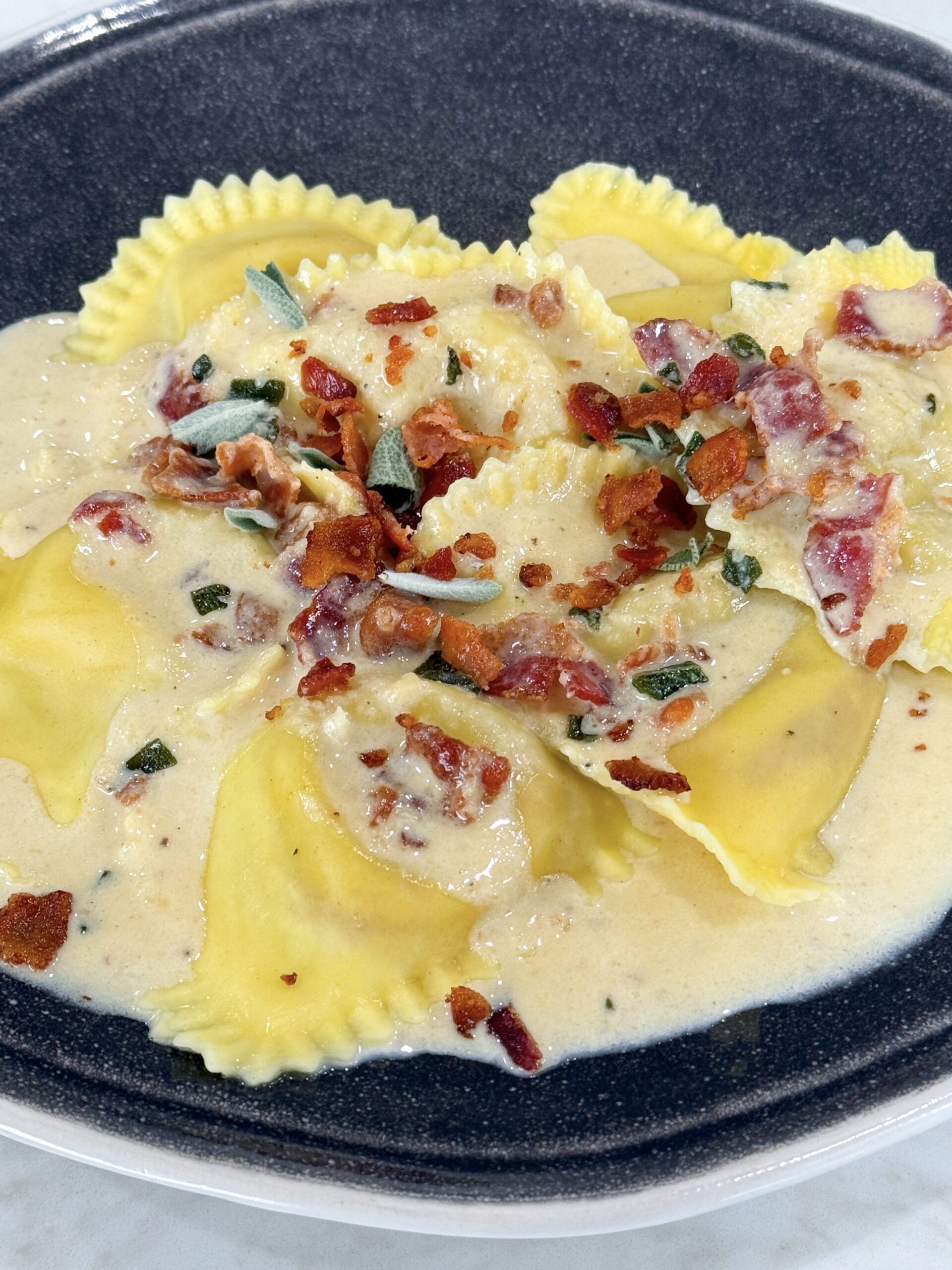 Butternut squash ravioli in creamy maple bacon sage sauce.