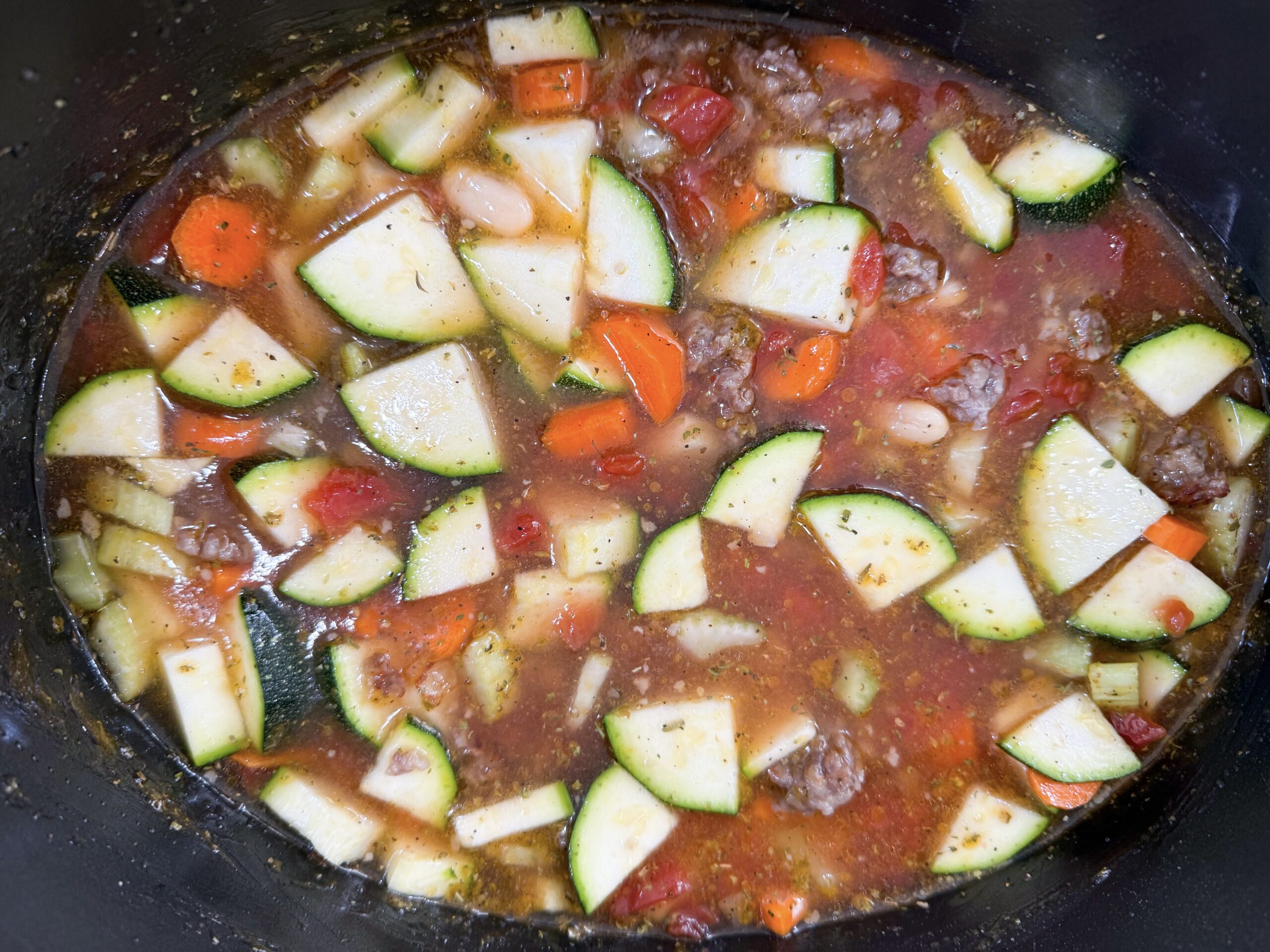 Vegetables, beans, seasonings, and broth in slow cooker