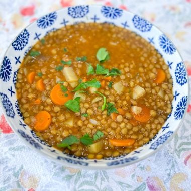 Bowl of lentil stew with carrots, potatoes, and spinach