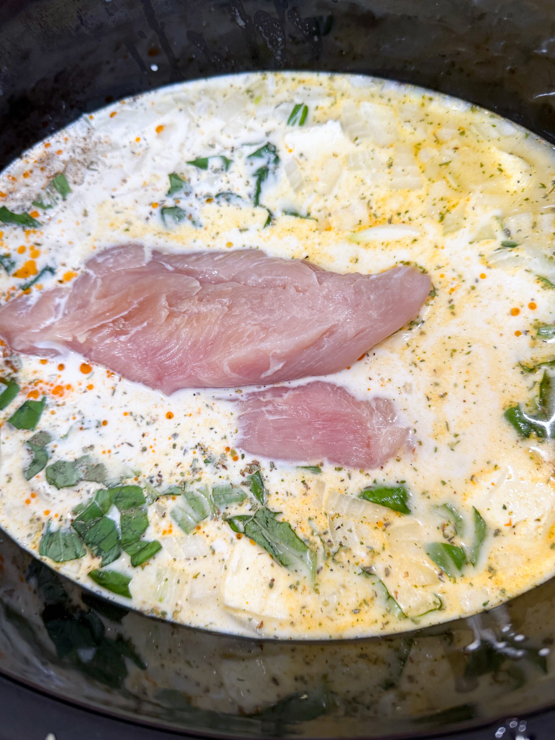 Chicken, cream cheese, and broth in slow cooker before cooking