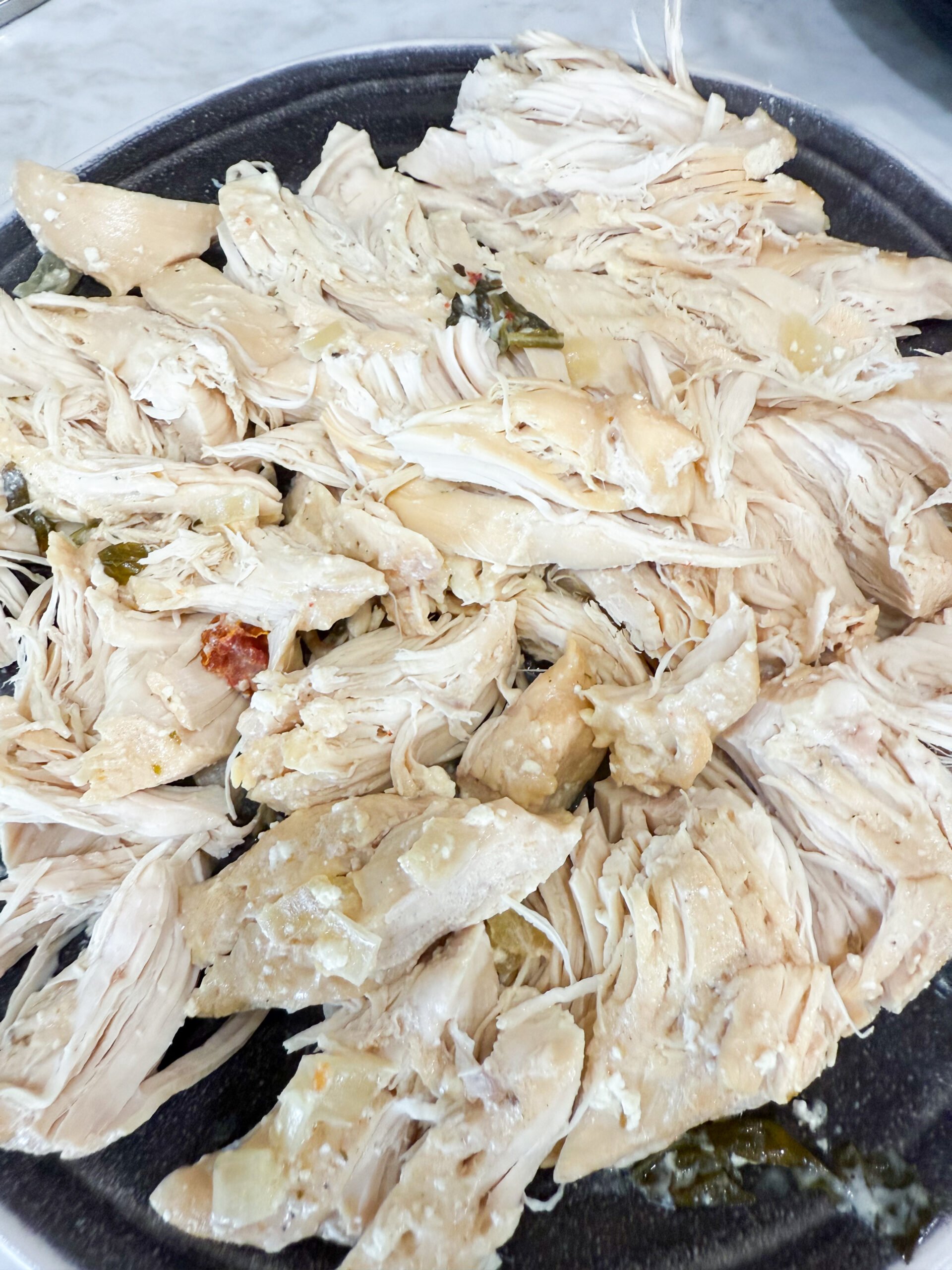 Shredded chicken on cutting board