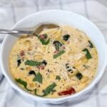 Bowl of creamy Slow Cooker Marry Me Chicken Soup with pasta, spinach, and sun-dried tomatoes