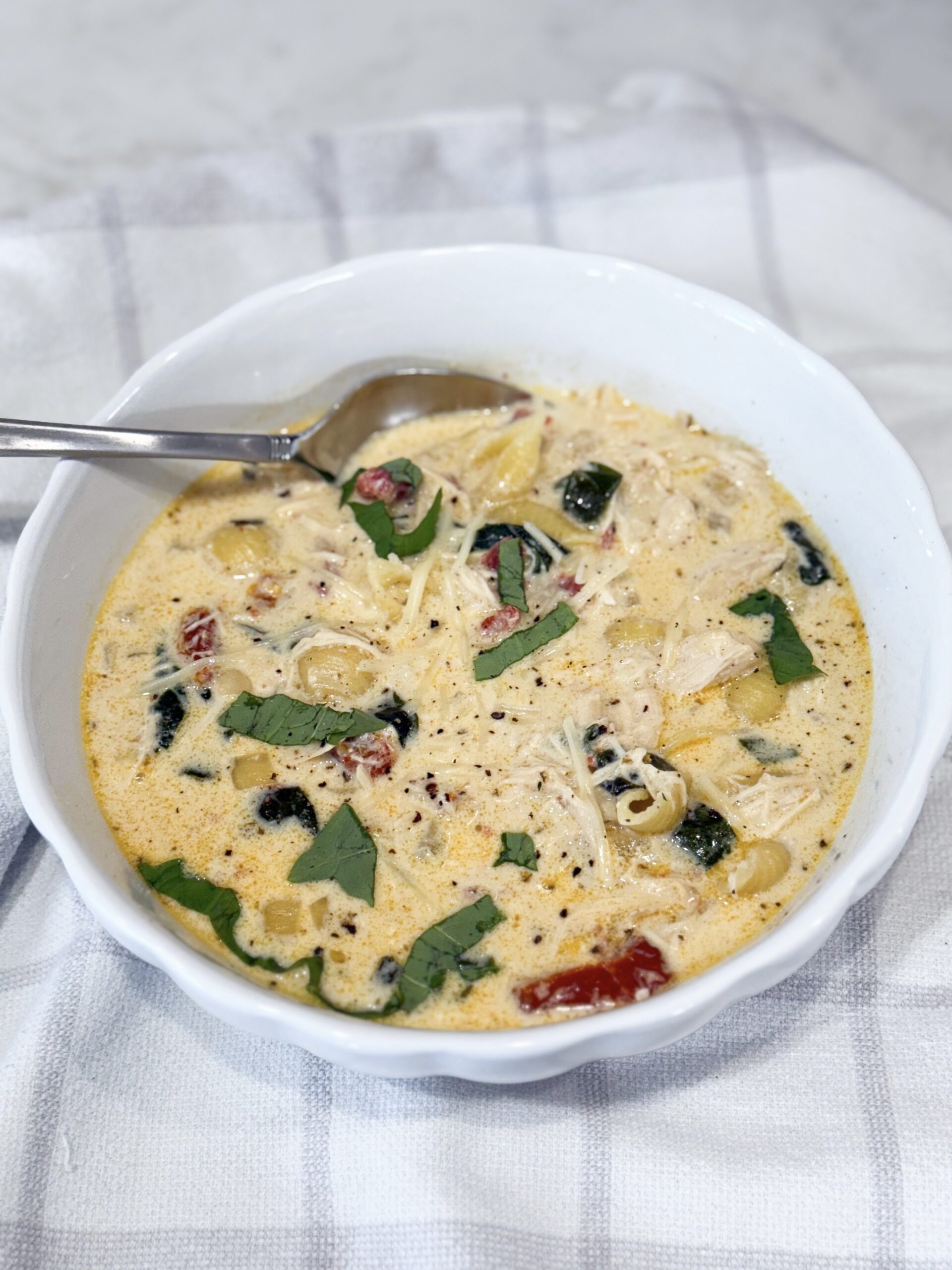 ALT text: Bowl of Slow Cooker Marry Me Chicken Soup with pasta, spinach, and Parmesan.
