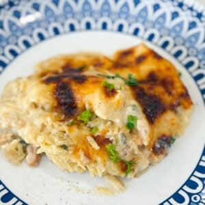 Serving of Spinach Chicken Orzo Casserole on a plate with creamy orzo, spinach, and melted cheese.